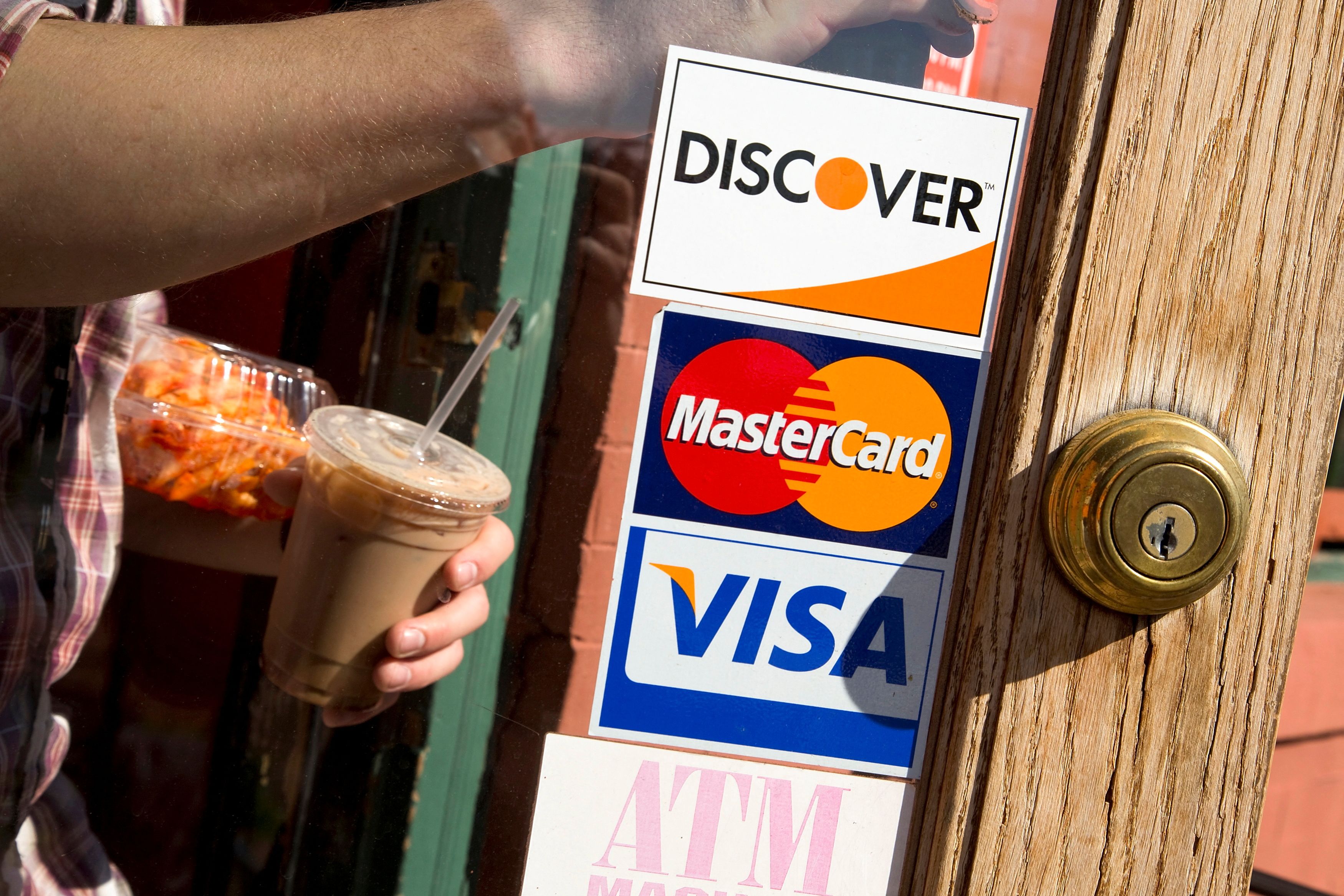 A coffee shop displays signs for Visa, MasterCard and Discover in Washington