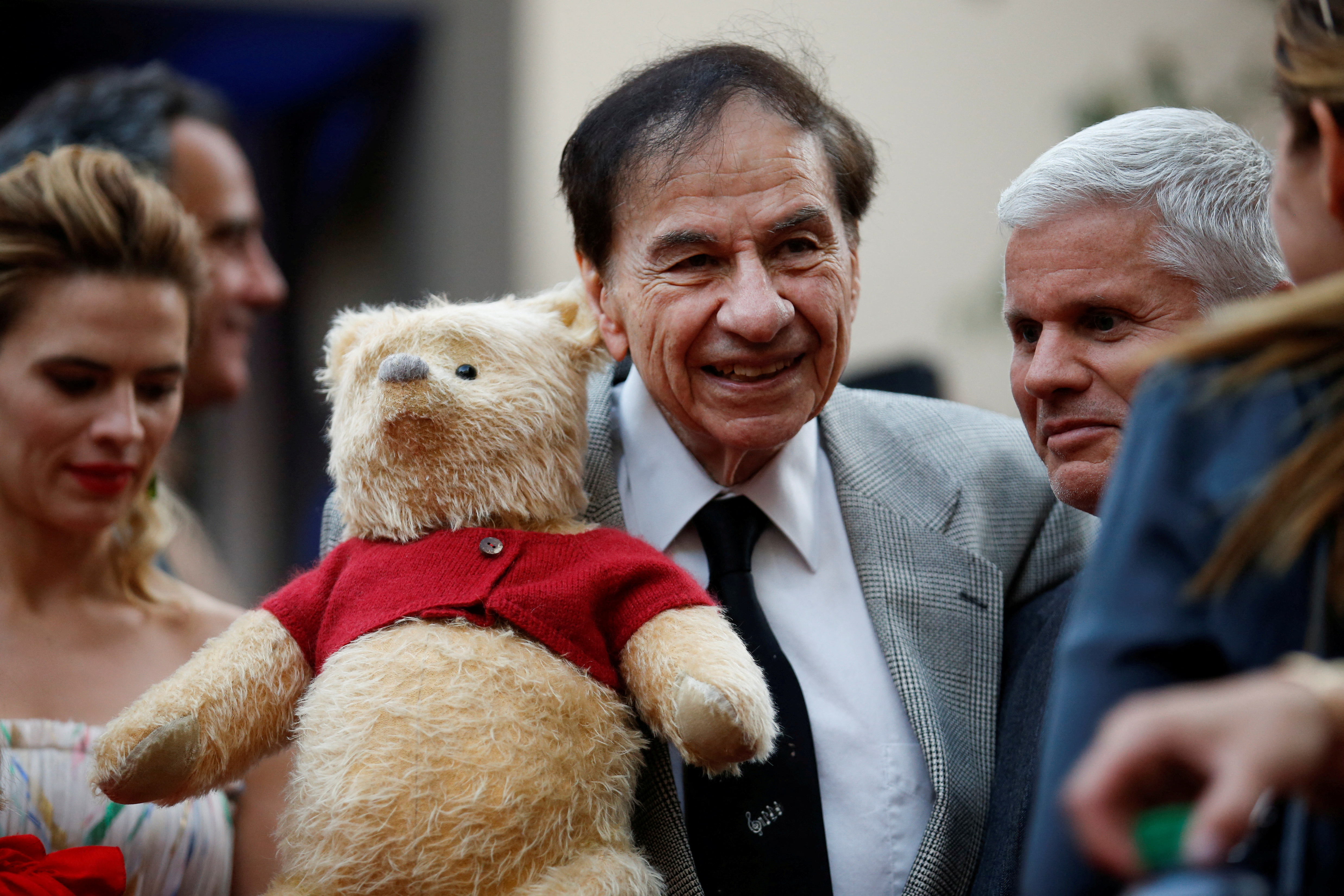 Songwriter Richard M. Sherman holds a stuffed Winnie the Pooh as he poses at the world premiere of Disney's 