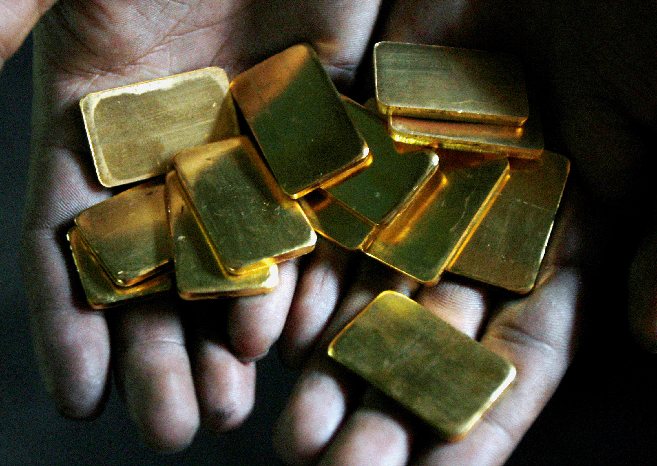 A worker shows gold biscuits at a precious metals refinery in Mumbai