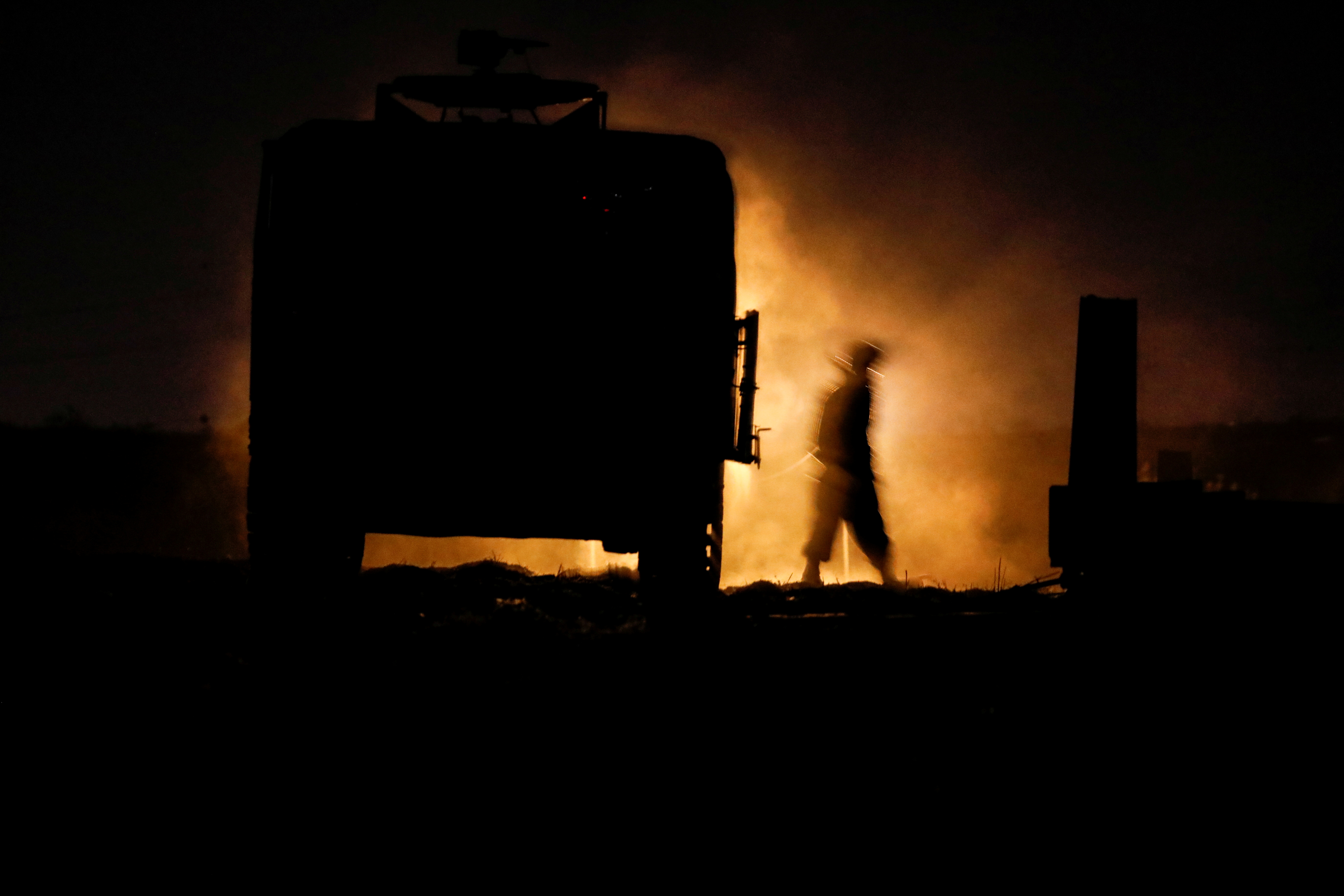 Israel pounds Gaza as fighting enters second week 7 An Israeli soldier walks next to a military vehicle at a mobile artillery unit location on the Israeli side by the Israel border with Gaza May 16, 2021. REUTERS/Baz Ratner