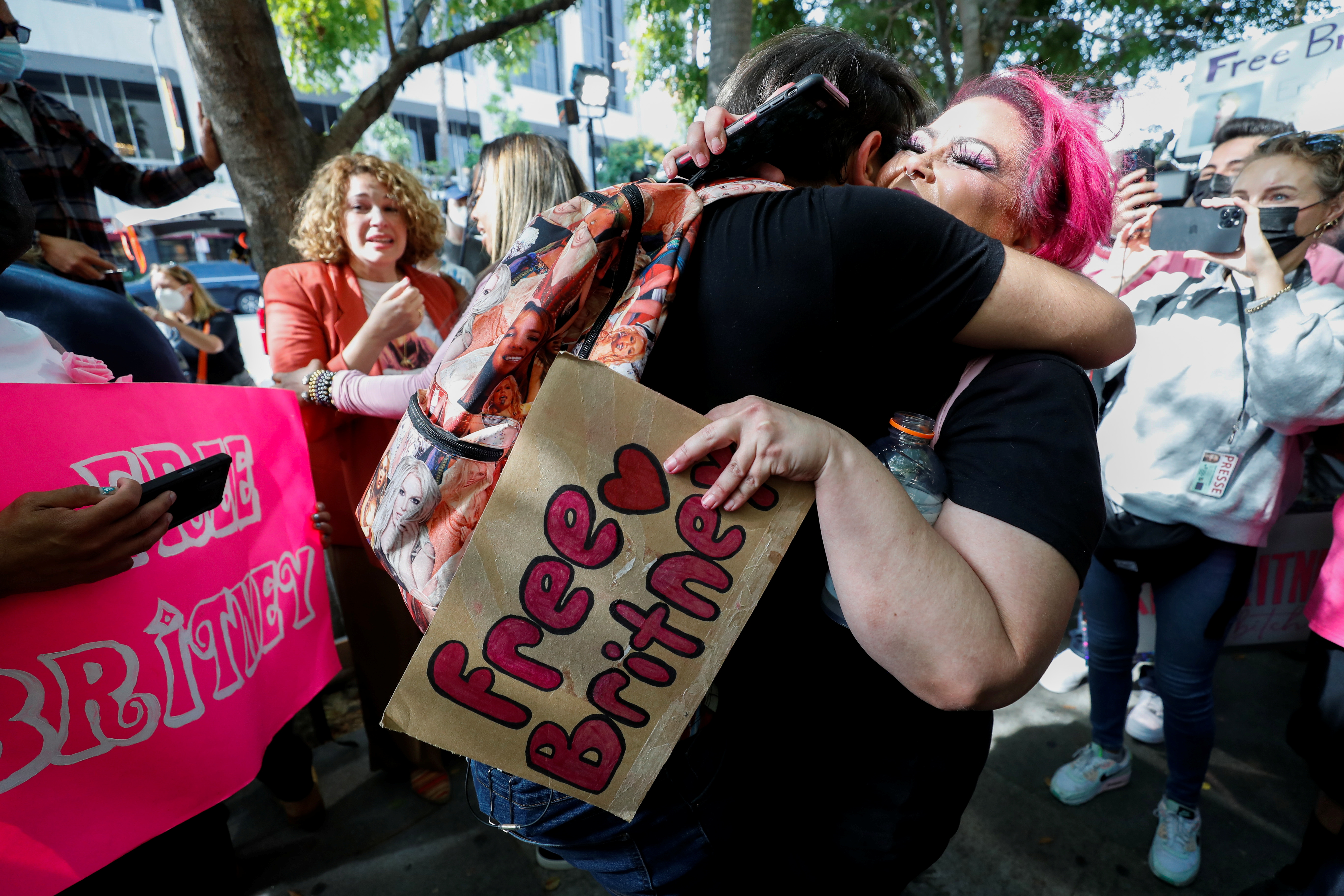 Supporters of pop star Britney Spears hug as they celebrate after a judge suspended the father of?Britney?Spears from his 13-years-long role as the controller of the singer's business affairs at Stanley Mosk Courthouse in Los Angeles, California, U.S., September 29, 2021. REUTERS/Mario Anzuoni