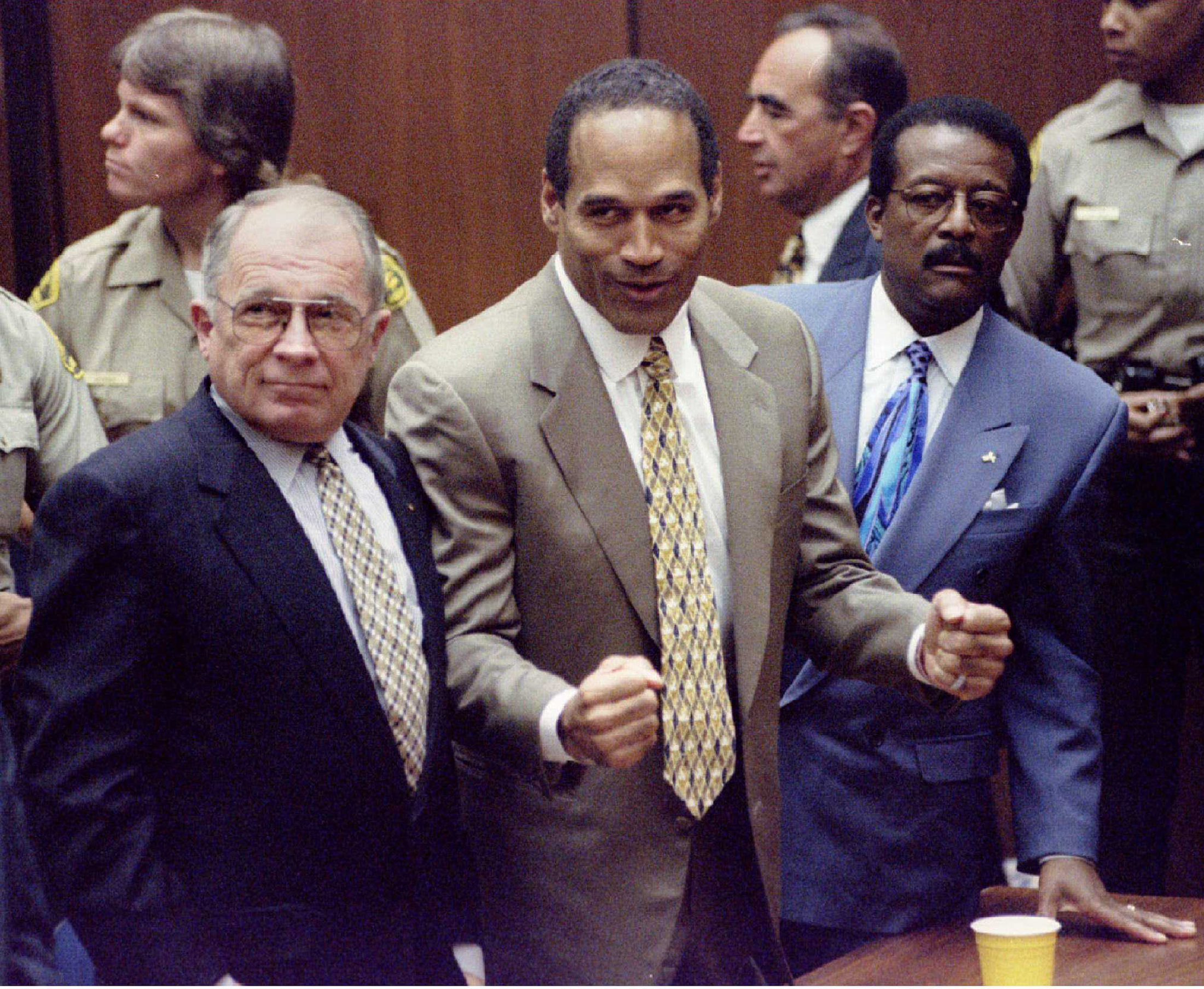 OJ Simpson reacts with lawyers after court clerk announces not guilty verdict in his murder trial