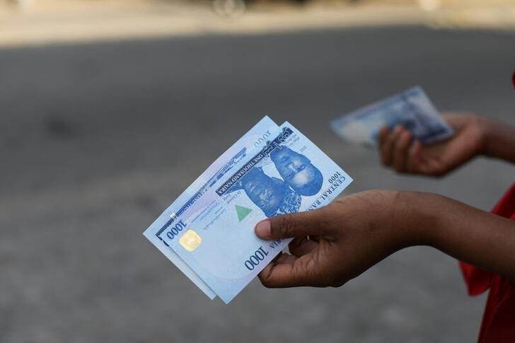 A person holds a new 1000 Naira note as the Central Bank of Nigeria releases the notes to the public through the banks in Abuja
