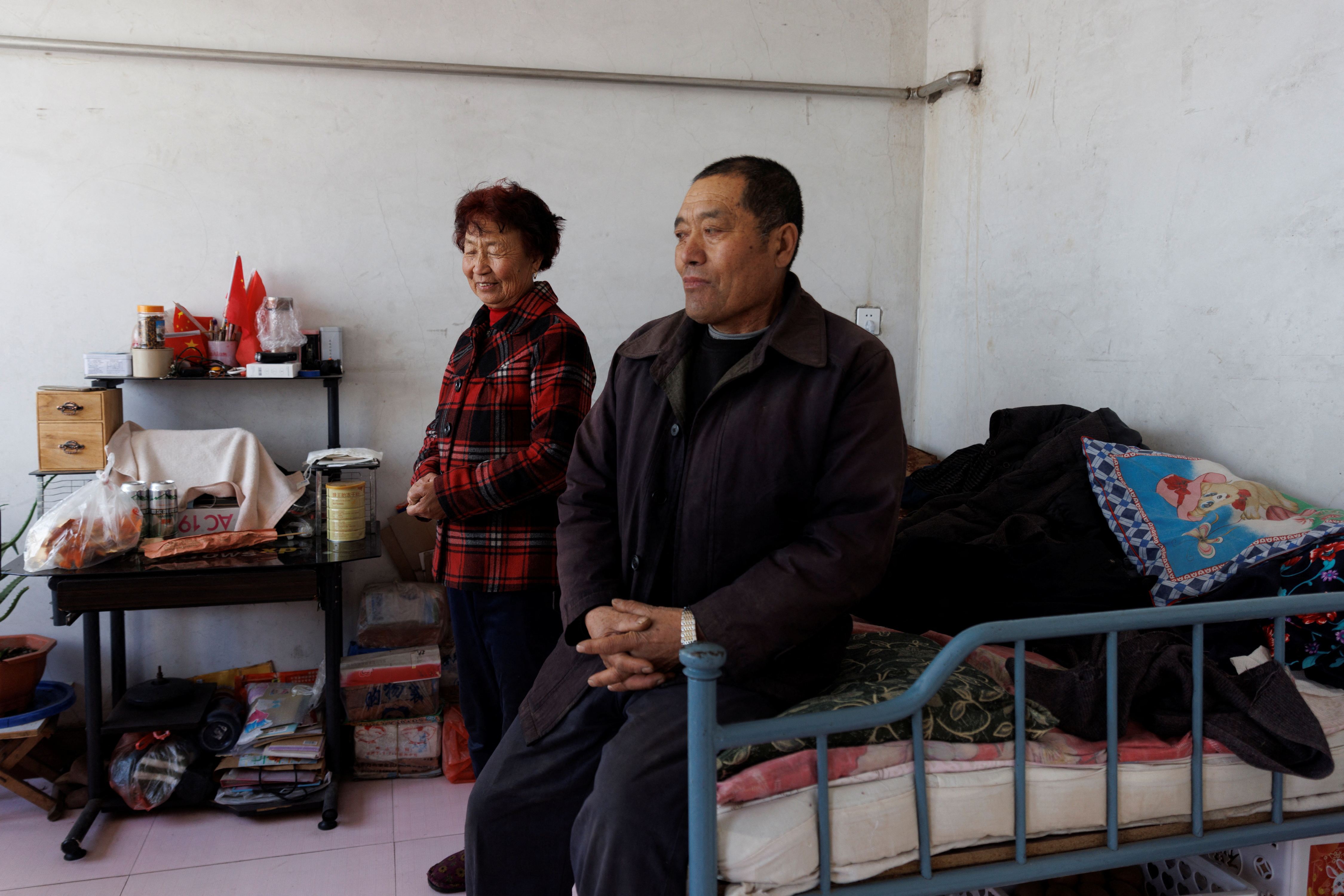 Farmer Wang Zhanling sits next to his wife in their house in Quansheng village