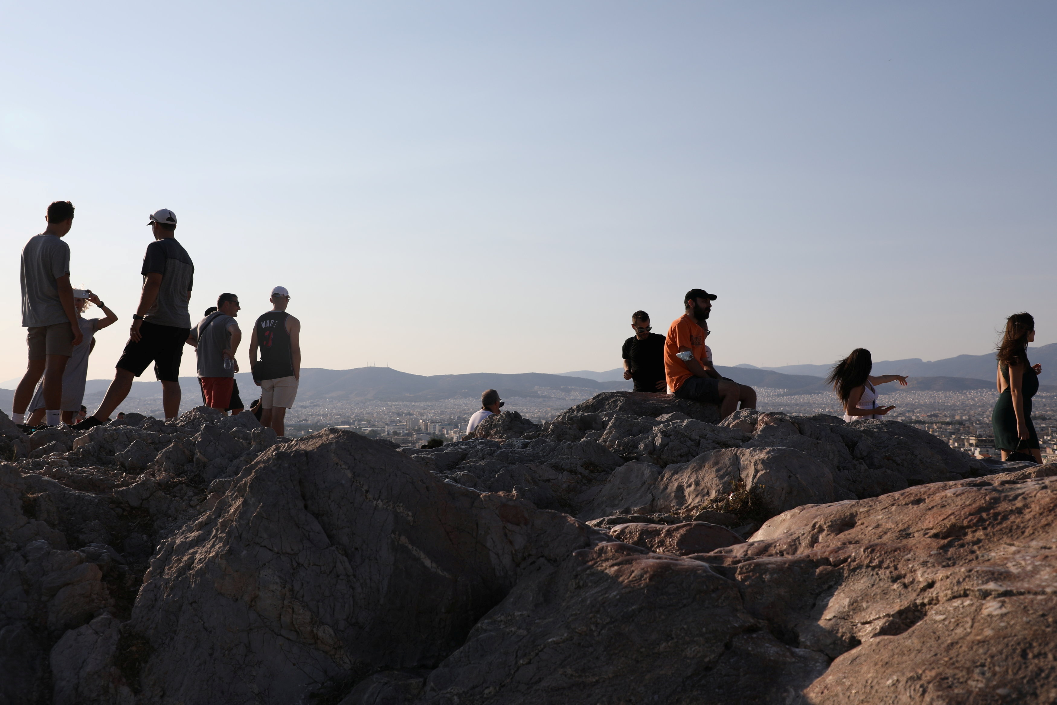 Cilvēki apmeklē Areios Pagos kalnu Atēnās, Grieķijā, 25. gada 2021. jūlijā. Attēls uzņemts 25. gada 2021. jūlijā. REUTERS / Louiza Vradi
