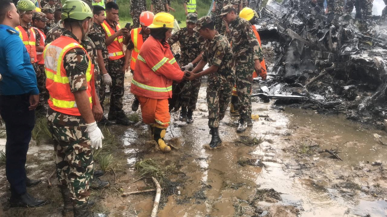 Rescuers gather at burnt wreckage of crashed aircraft, in Kathmandu