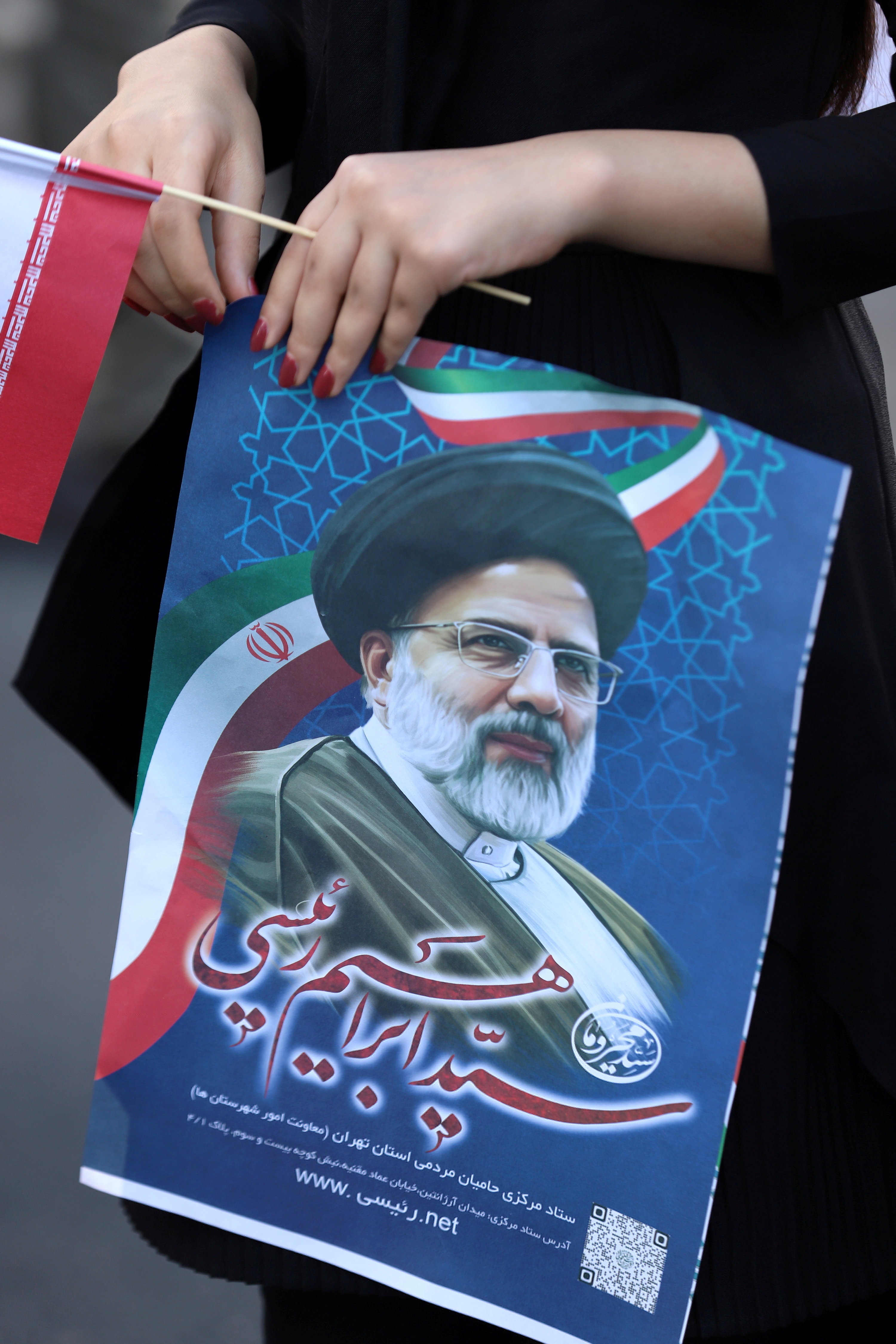 A supporter of presidential candidate Ebrahim Raisi holds a poster of him during an election rally in Tehran, Iran June 11, 2021.