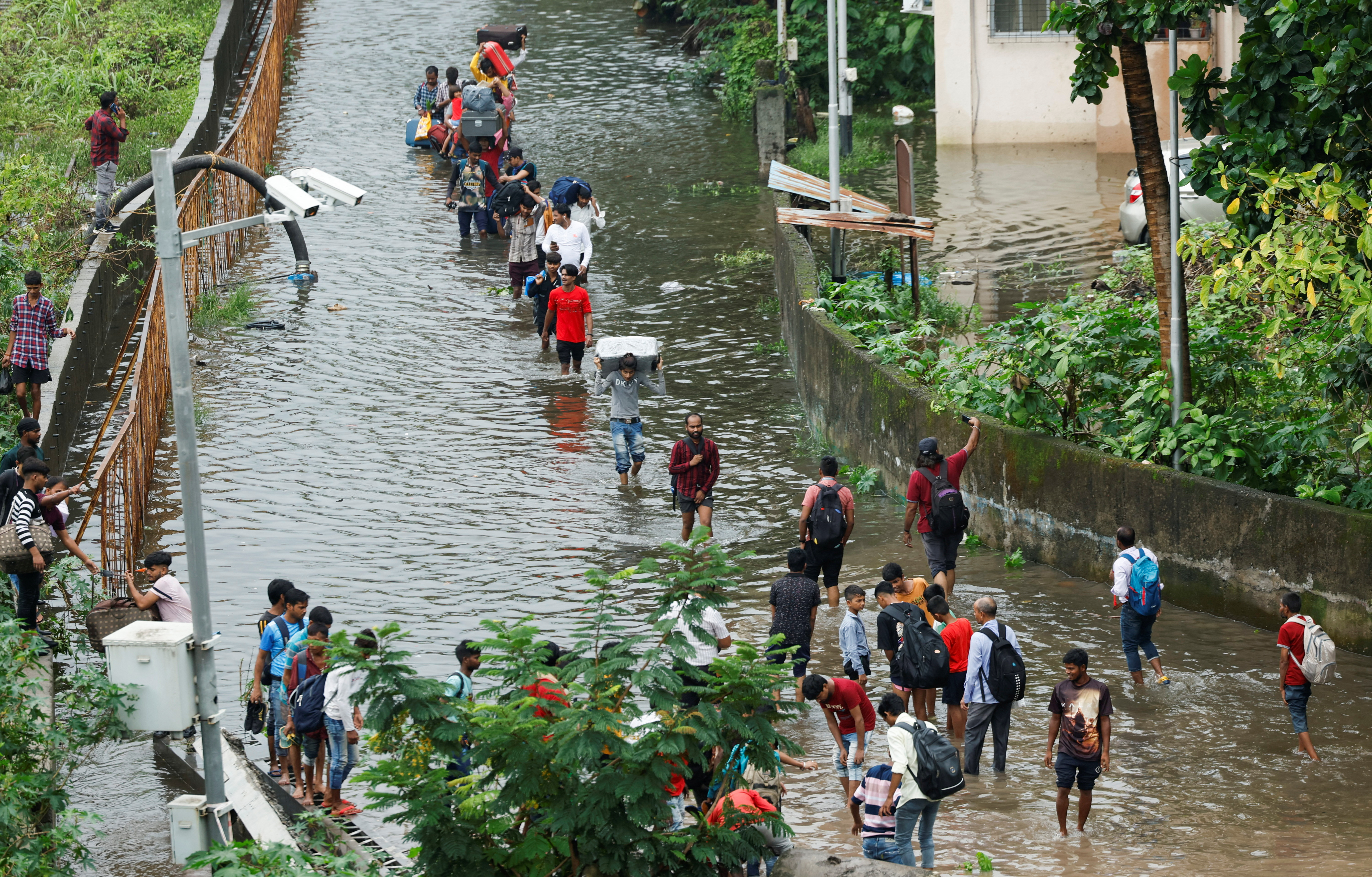 People walk on a waterlogged street after heavy rains in Mumbai