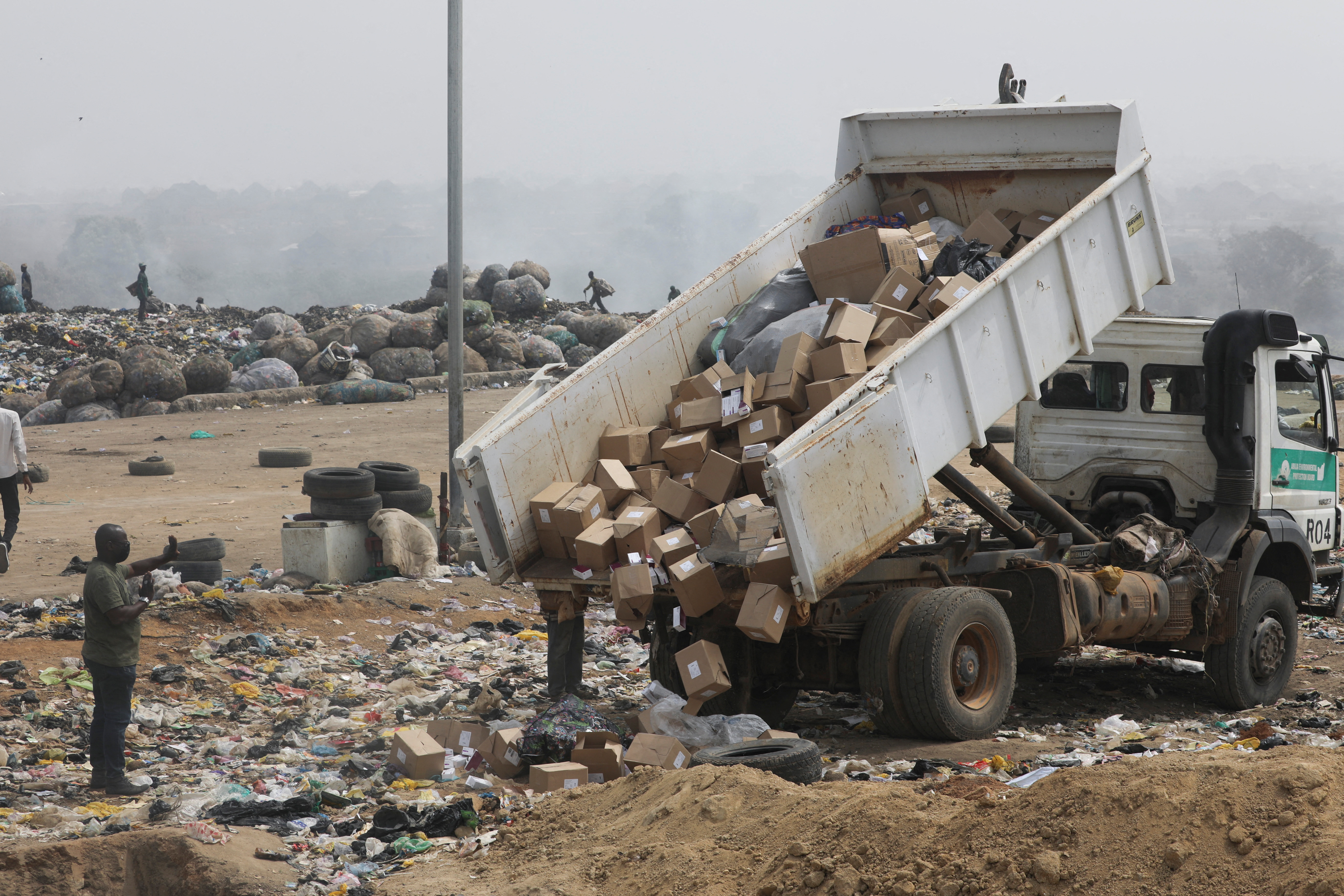 A truck offloads expired AstraZeneca COVID-19 vaccines at the Gosa dump site in Abuja