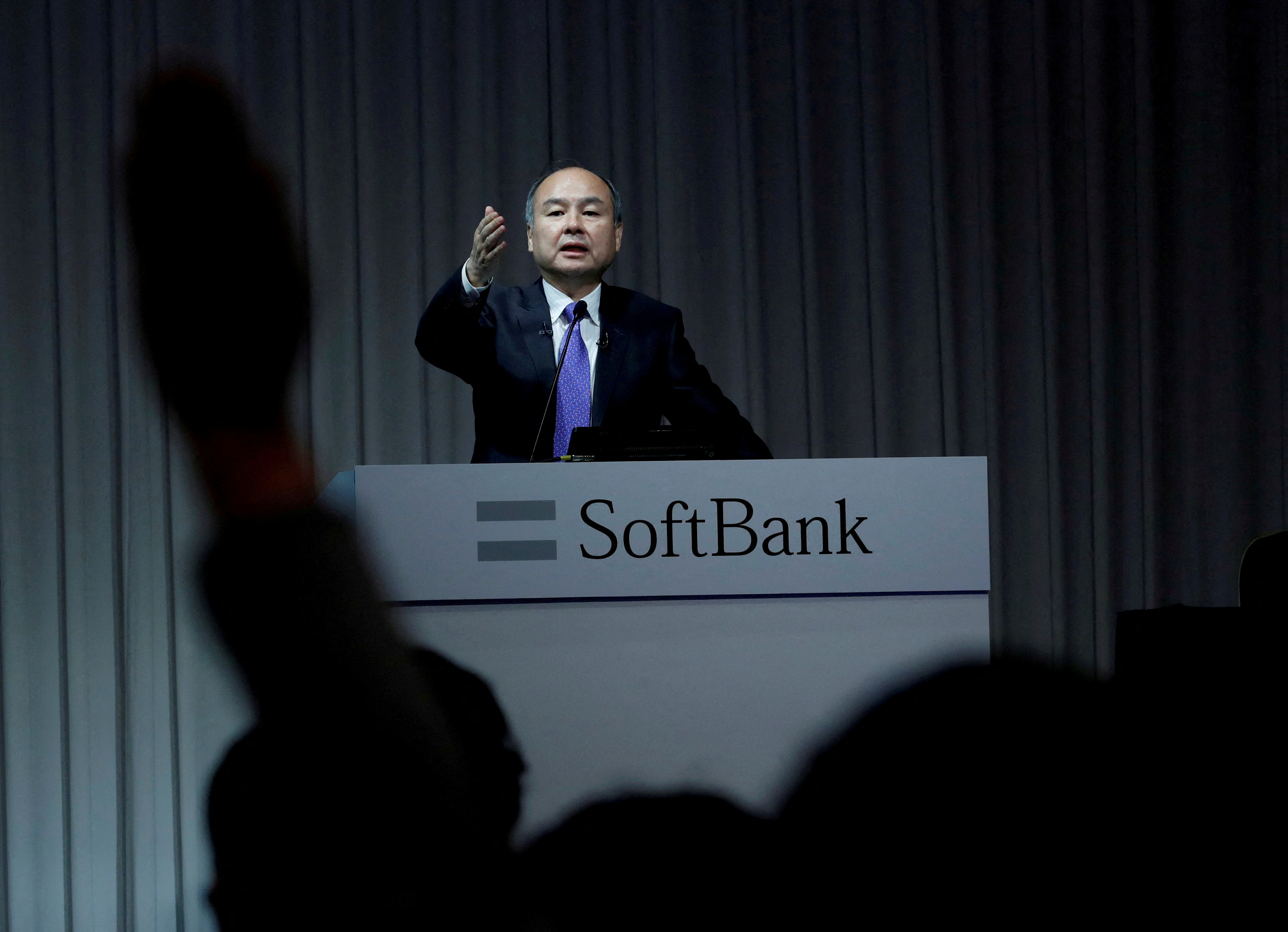 A journalist raises her hand to ask a question to Japan's SoftBank Group Corp Chief Executive Masayoshi Son during a news conference in Tokyo