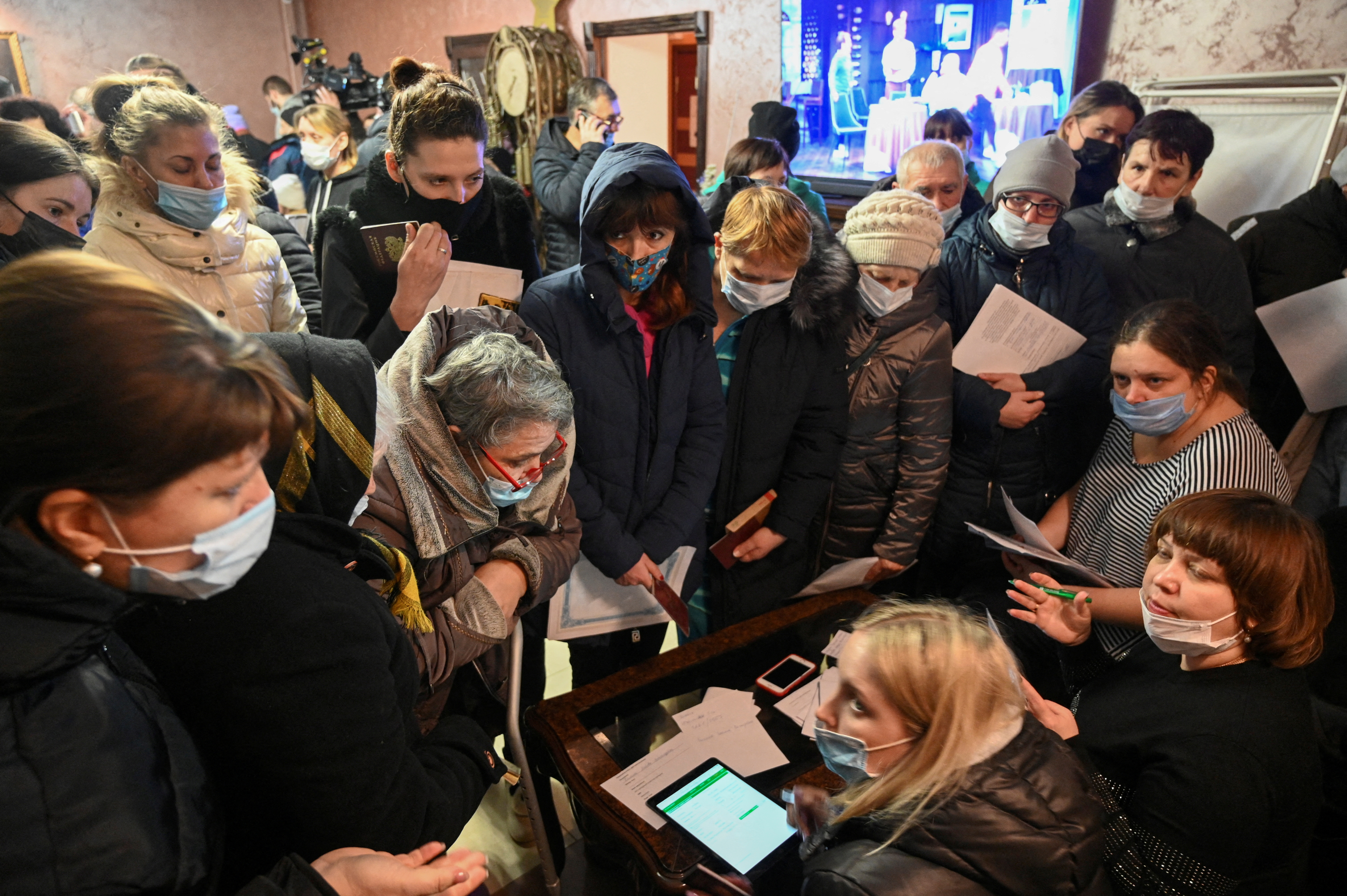 People, who were evacuated from the separatist-controlled regions of eastern Ukraine, fill in and submit documents in a temporary accommodation centre located at the recreation facility Zvezda in the Rostov region, Russia February 20, 2022. REUTERS/Sergey Pivovarov   