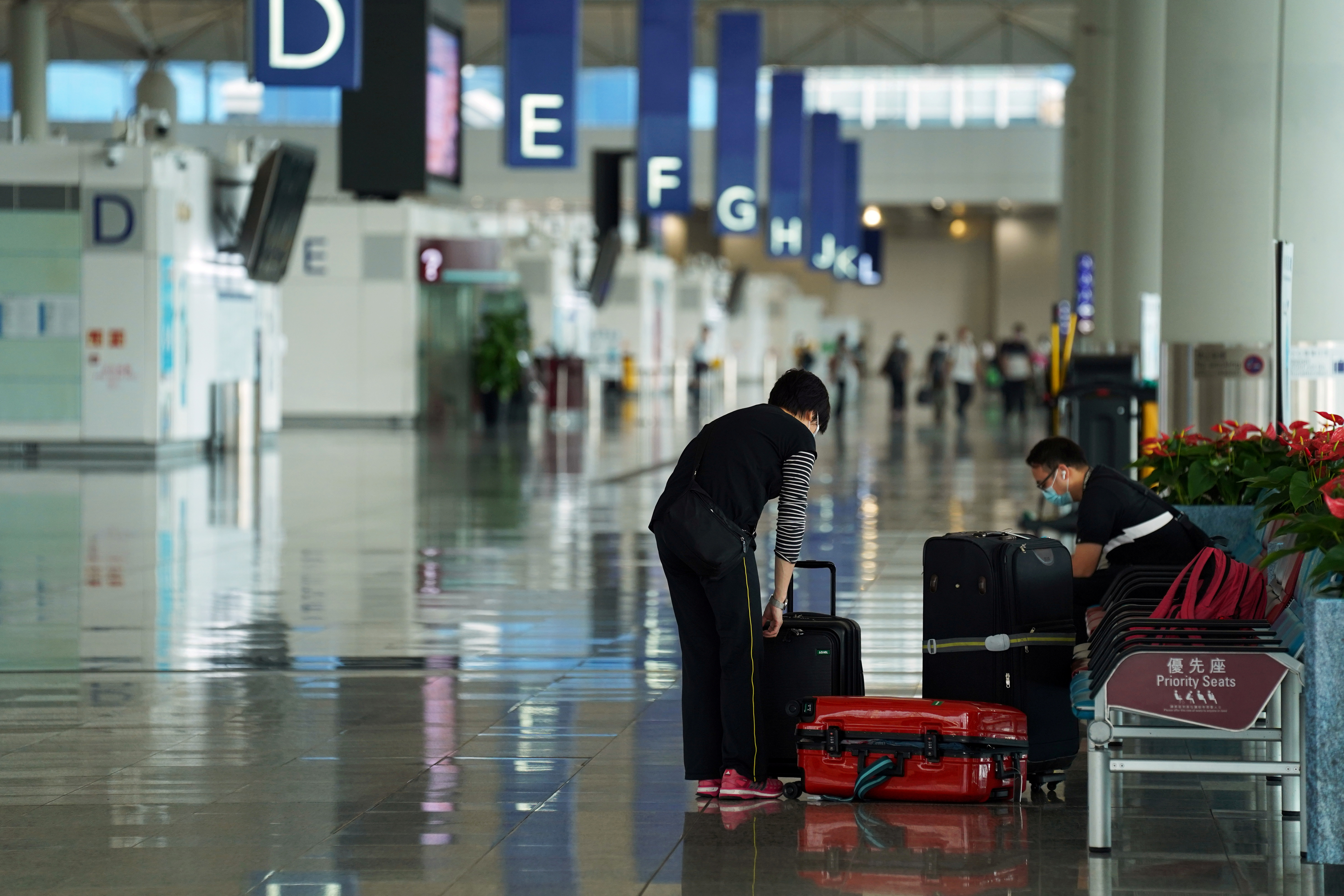 Woman sorts luggage at Hong Kong International Airport