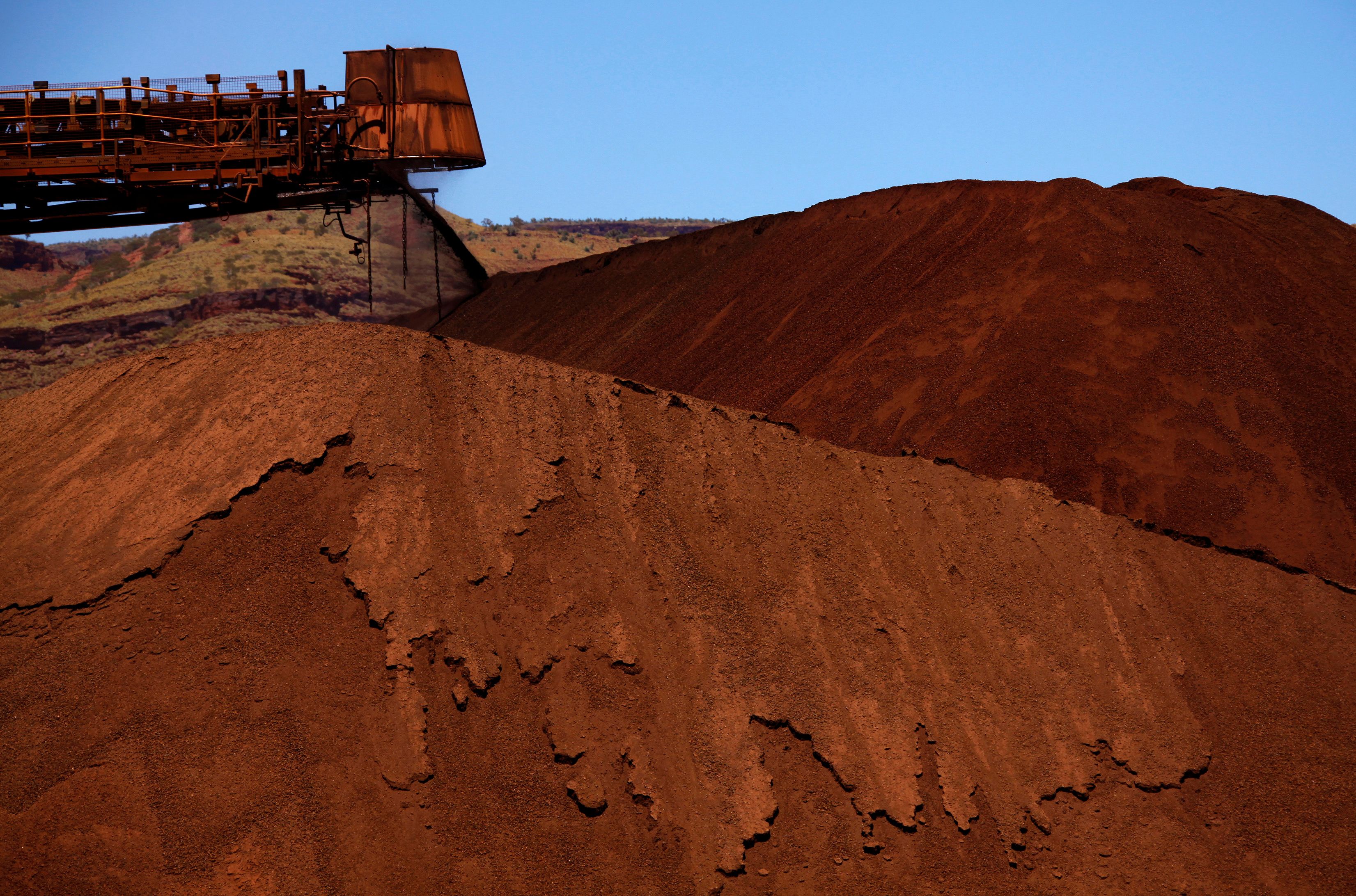 A stacker unloads iron ore onto a pile at a mine located in the Pilbara region of Western Australia December 2, 2013. REUTERS/David Gray
