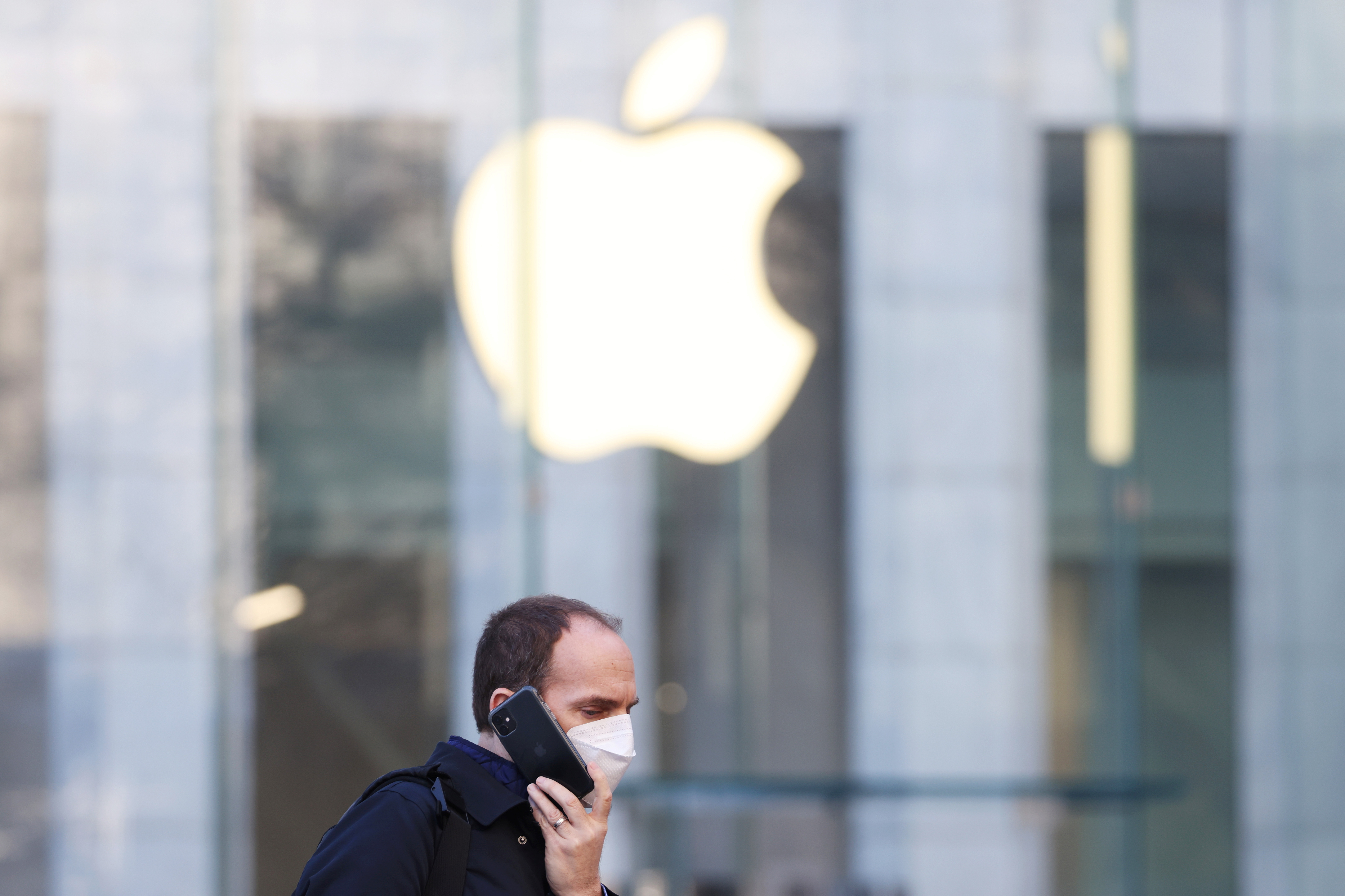 A person uses smartphone near an Apple Store in Manhattan, New York City