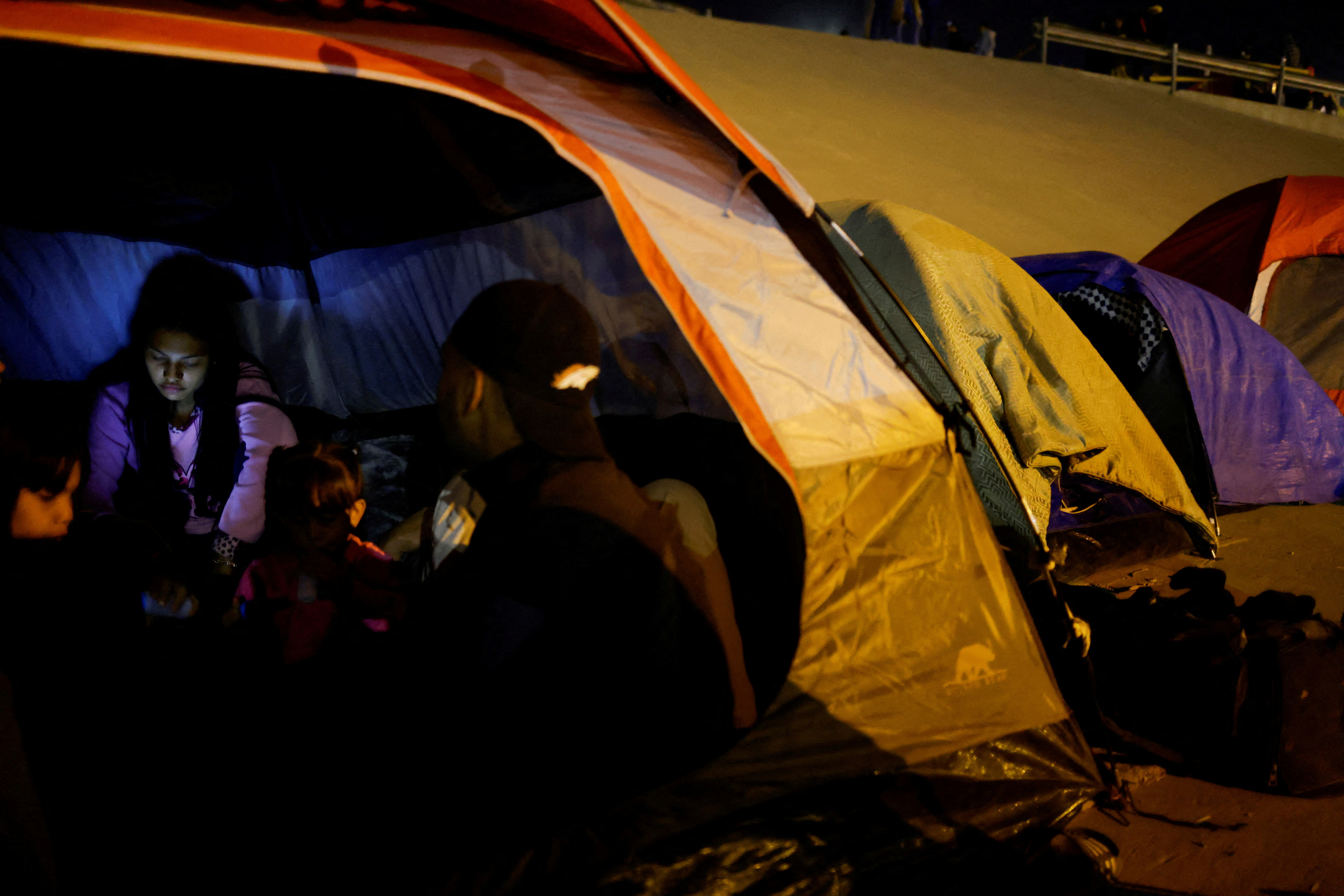 Venezuelan migrants stand in a camp on the banks of the Rio Bravo river, in Ciudad Juarez