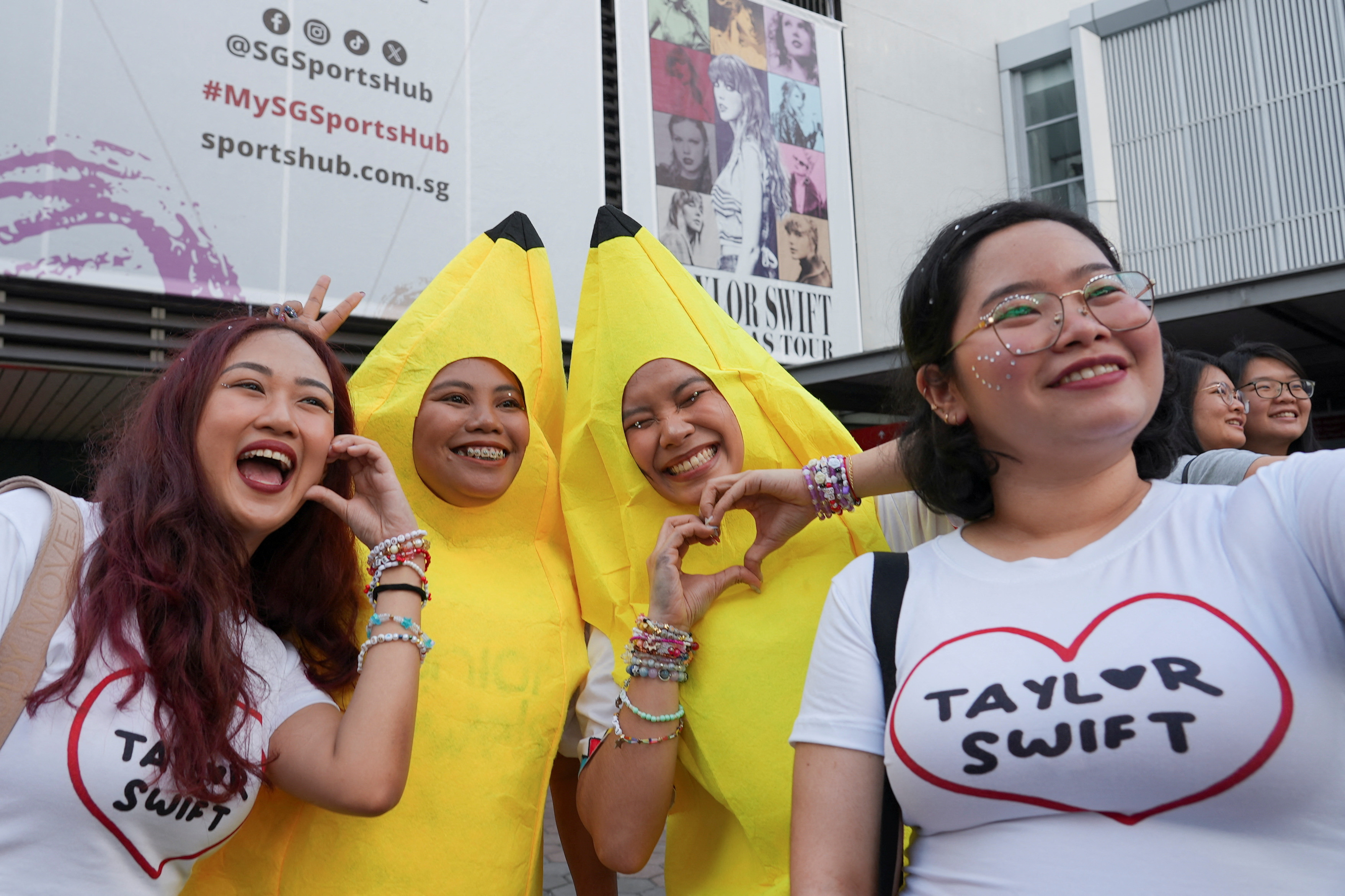 Filipina 'Swiftie' Charlyn Suizo poses for a selfie with other fans before a Taylor Swift concert, outside National Stadium in Singapore