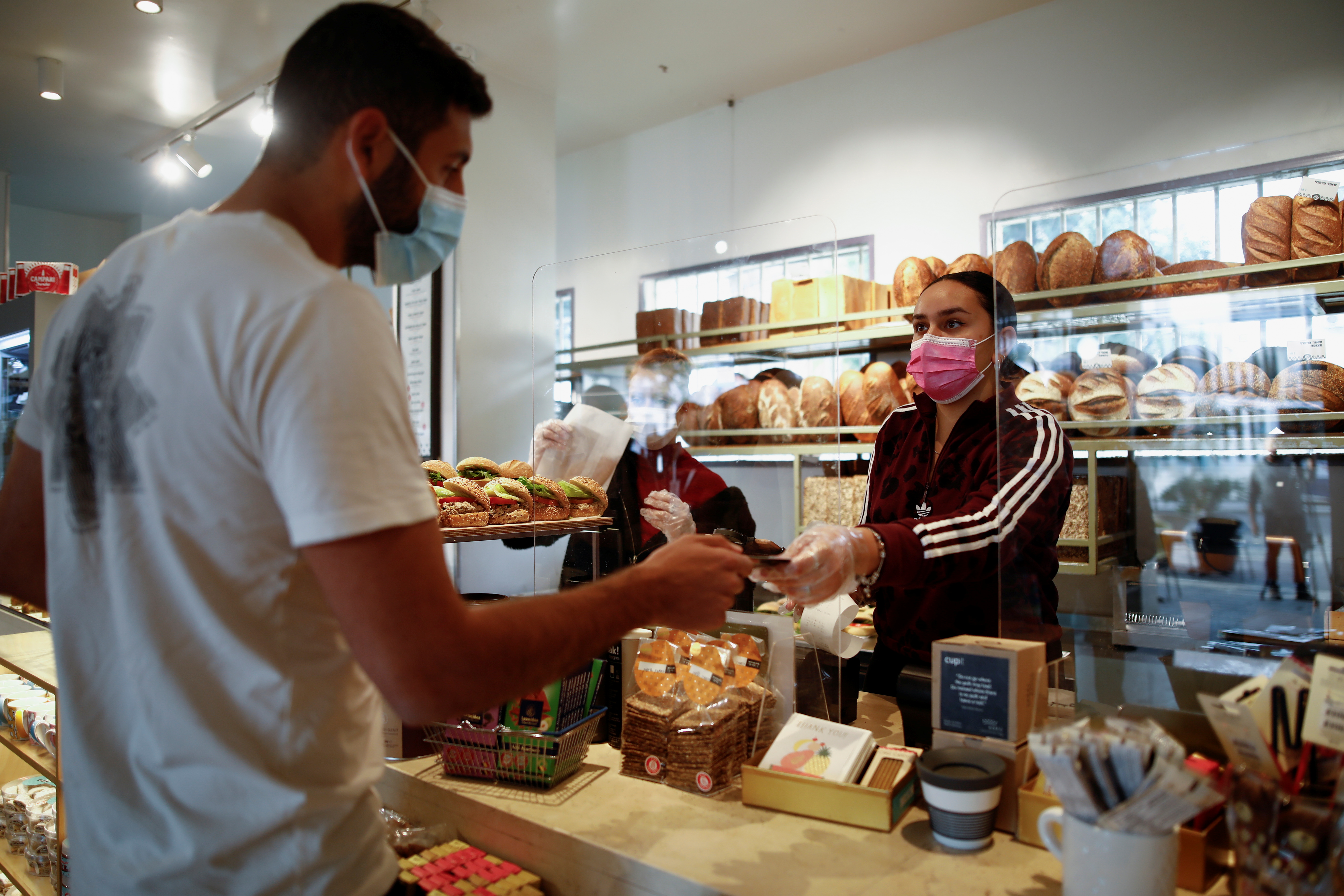 A customer pays at a cafe as Israel further eases the coronavirus disease (COVID-19) restrictions in Tel Aviv