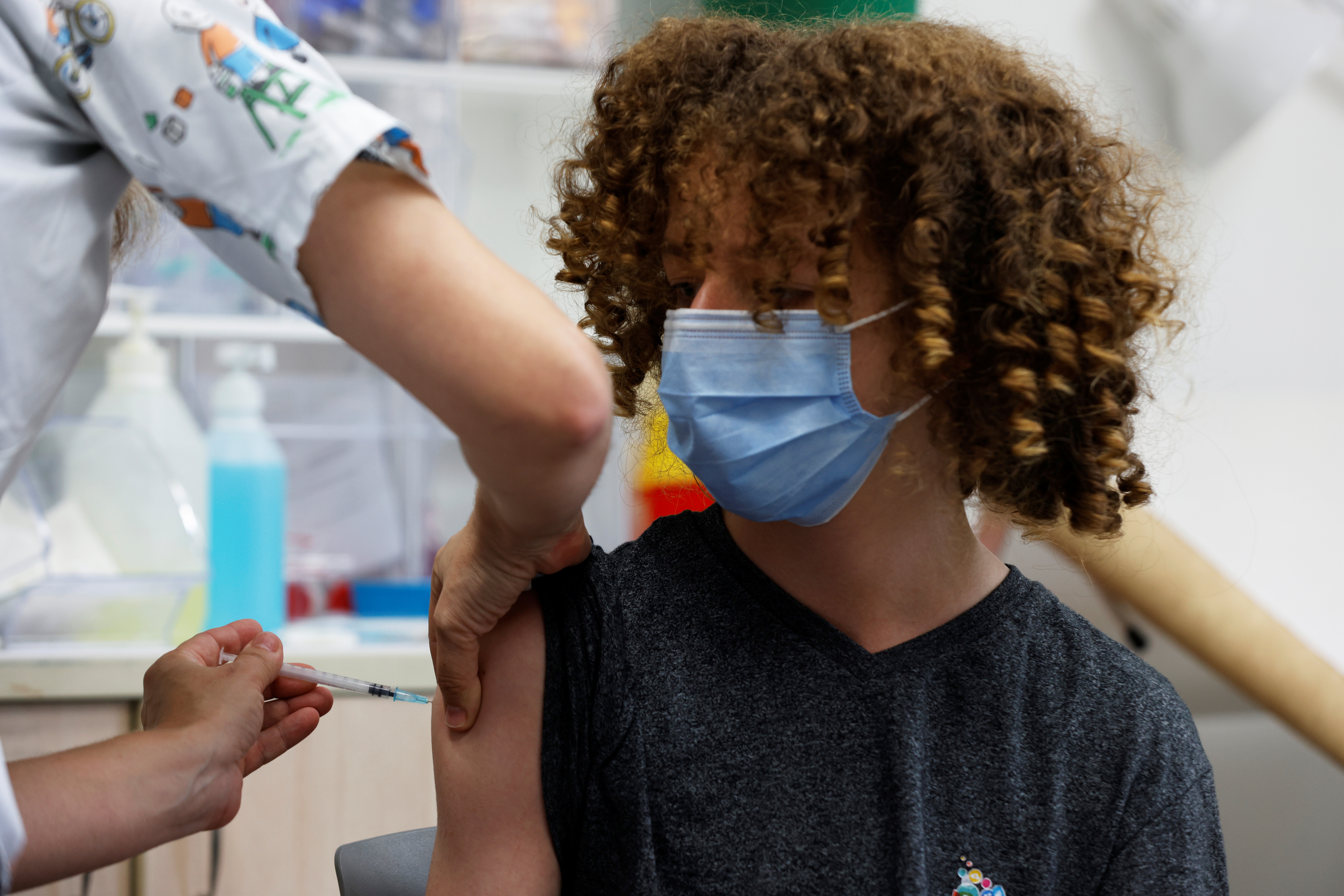 A teenager receives a dose of a vaccine against the coronavirus disease (COVID-19) in Tel Aviv