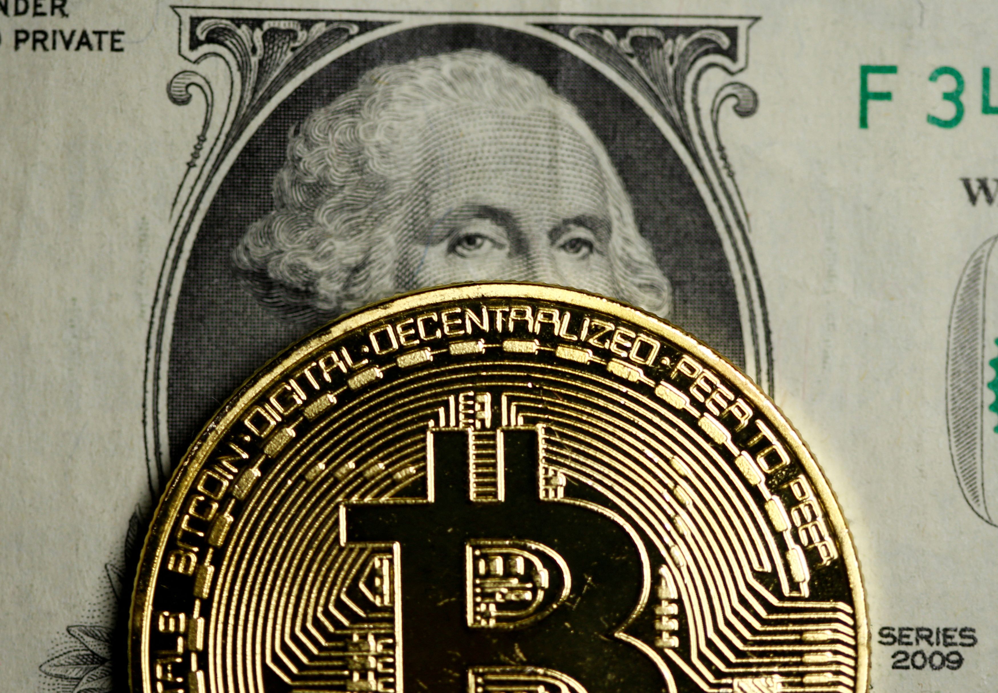 A Bitcoin and Dollar note are seen in this illustration picture