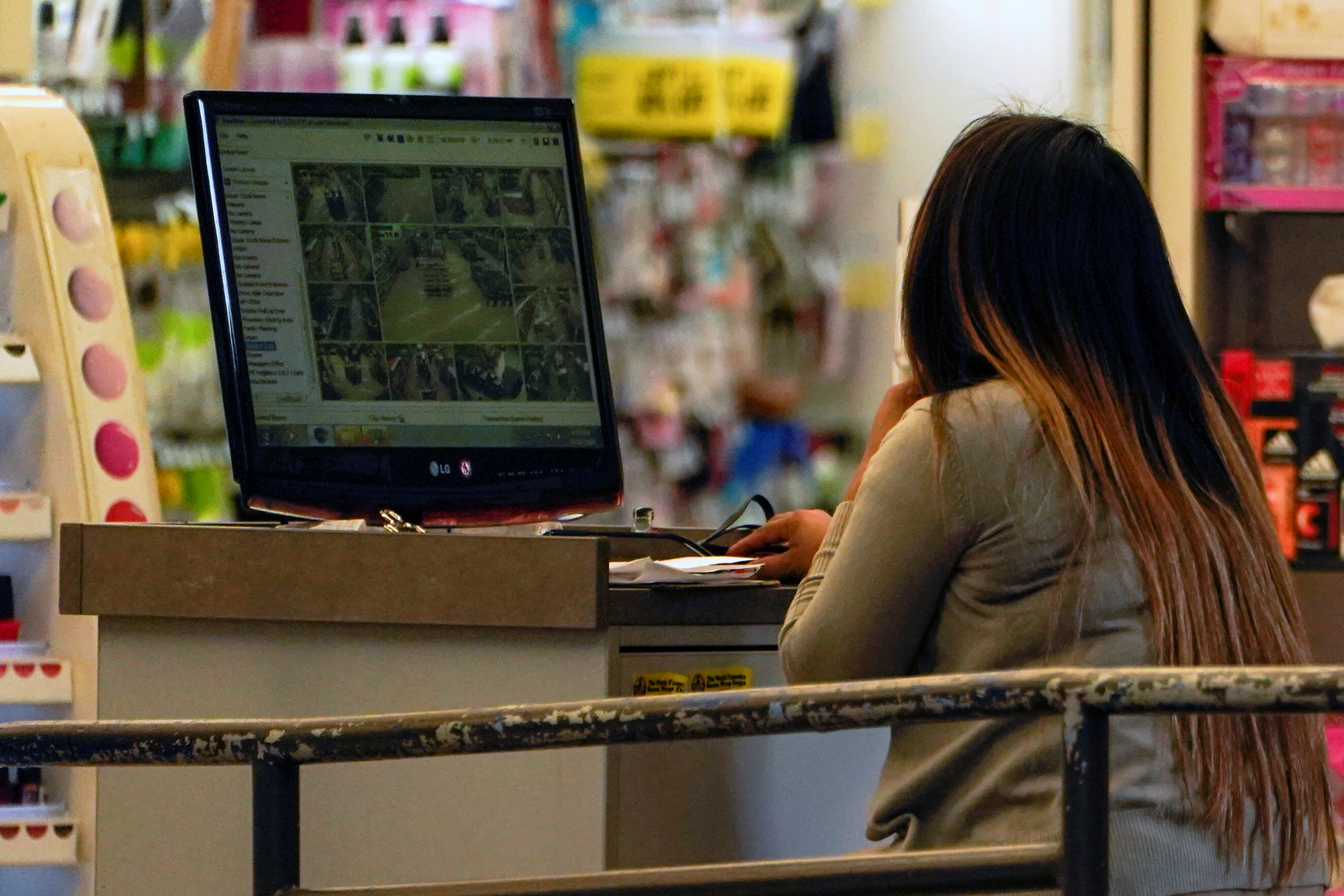 A Rite Aid store worker looks over security camera footage from facial recognition cameras in one of the company's stores in downtown Los Angeles