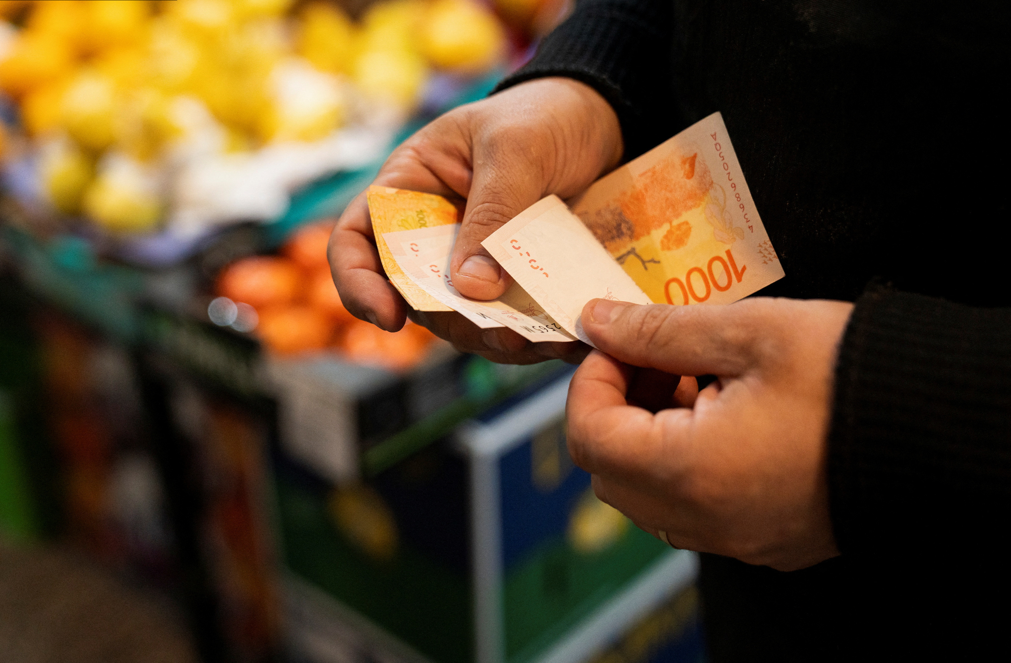 A greengrocer counts Argentine peso bills at a local market,as Argentina is due to release consumer inflation data for April, in Buenos Aires