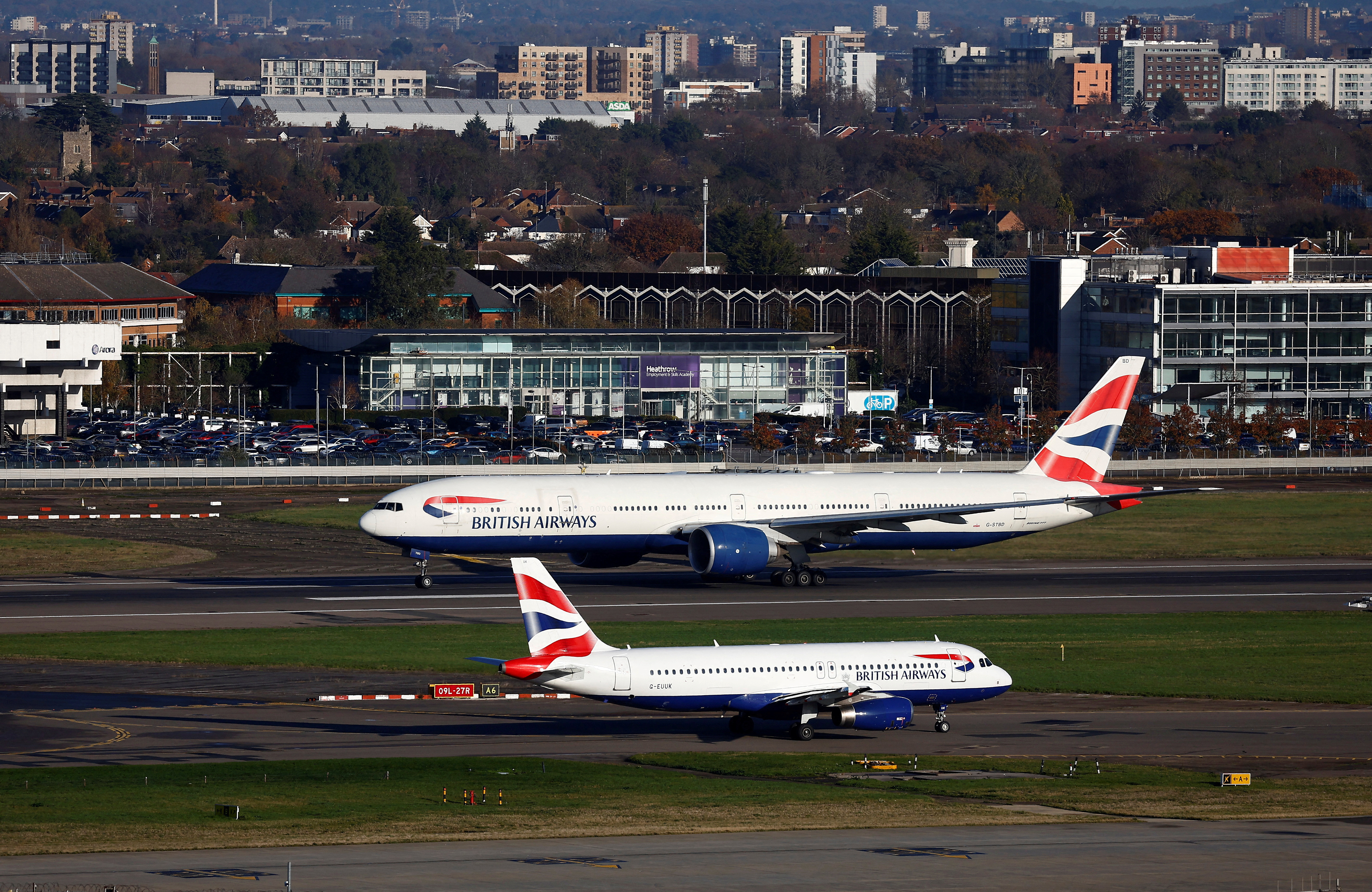 A British Airways Boeing 777 passes a British Airways Airbus as it takes off from Heathrow Airport