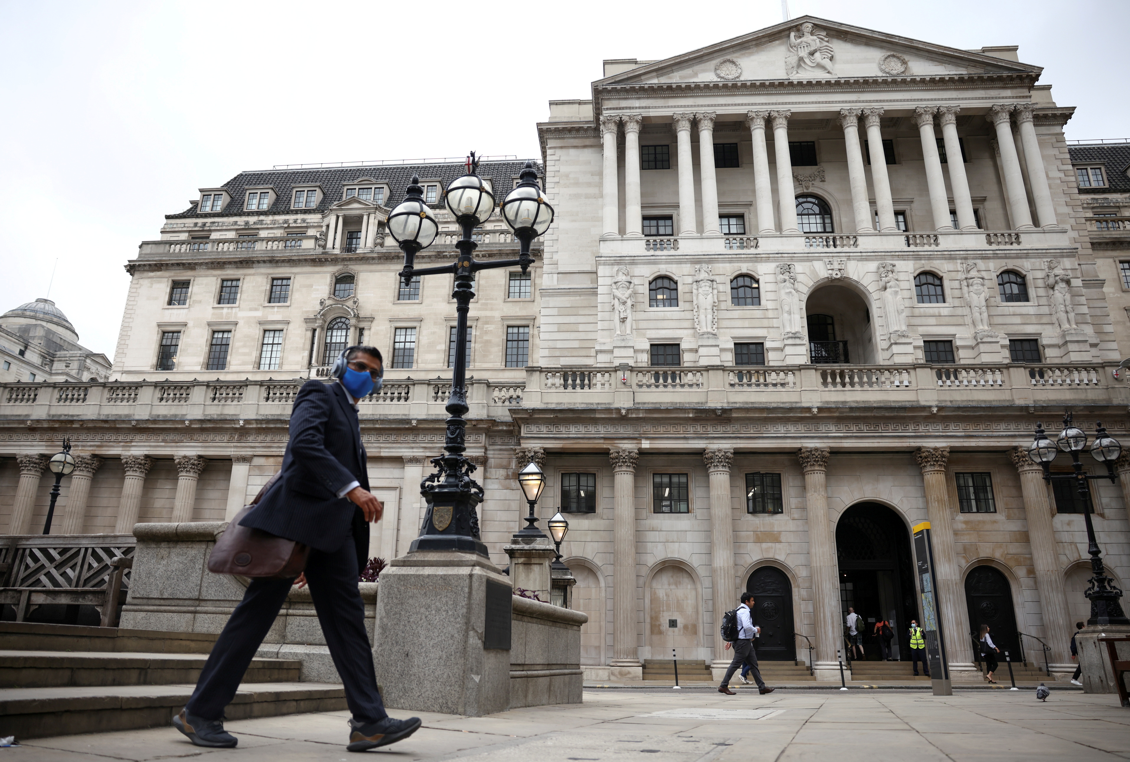 A person walks past the Bank of England in the City of London financial district