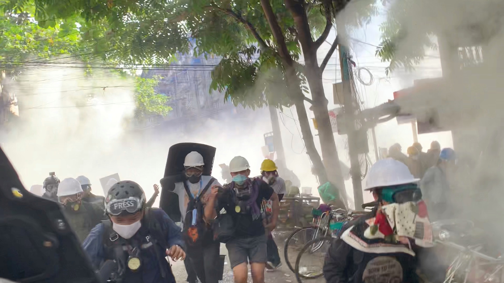 Video grab of protesters setting off smoke grenades to block the view from snipers in Sanchaung, Yangon, Myanmar