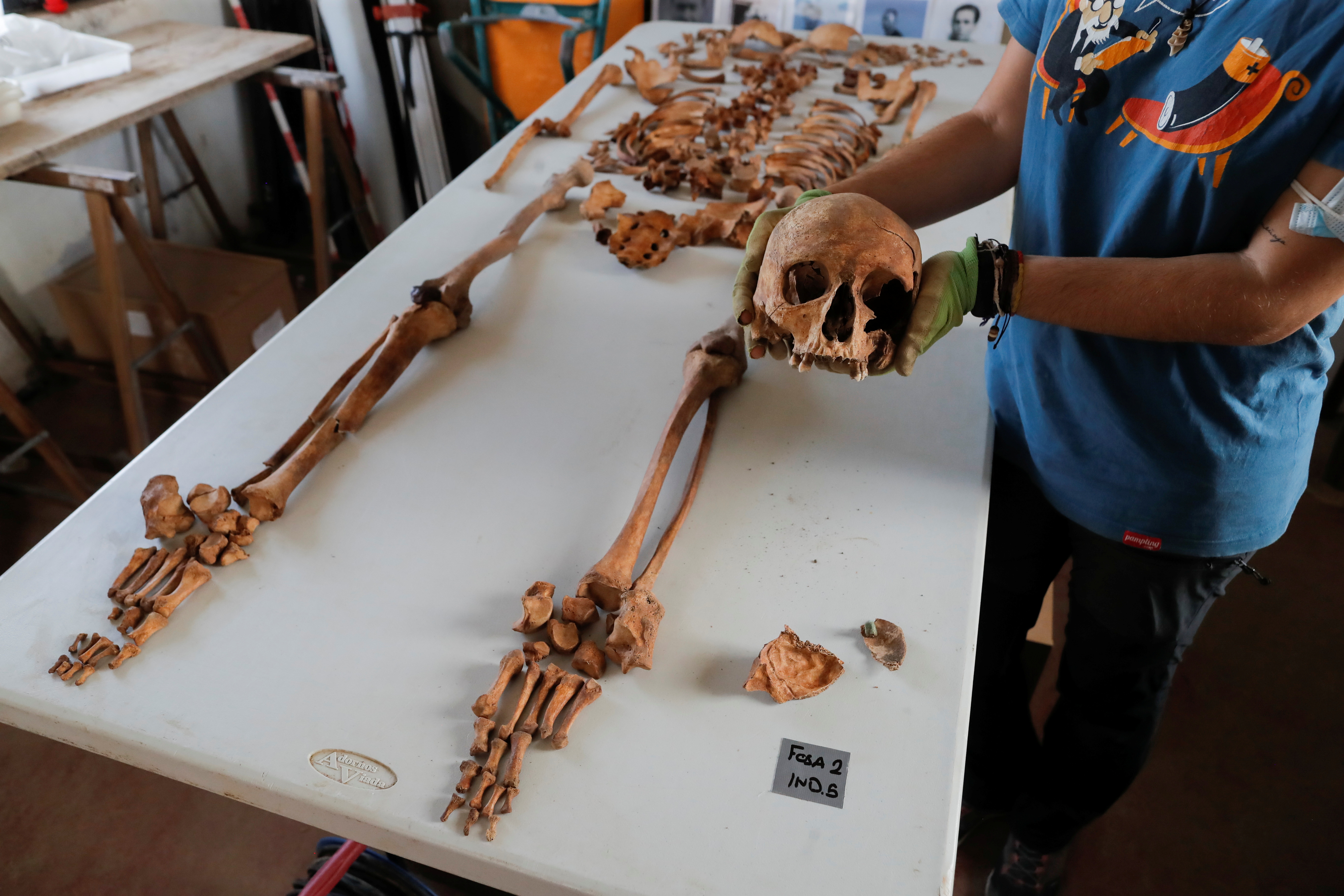 Archaeologist, Maria Jose Gamez, 32, holds the skull of a human skeleton after technical workers exhumed the remains of 18 people at a cemetery in Jimena de la Frontera