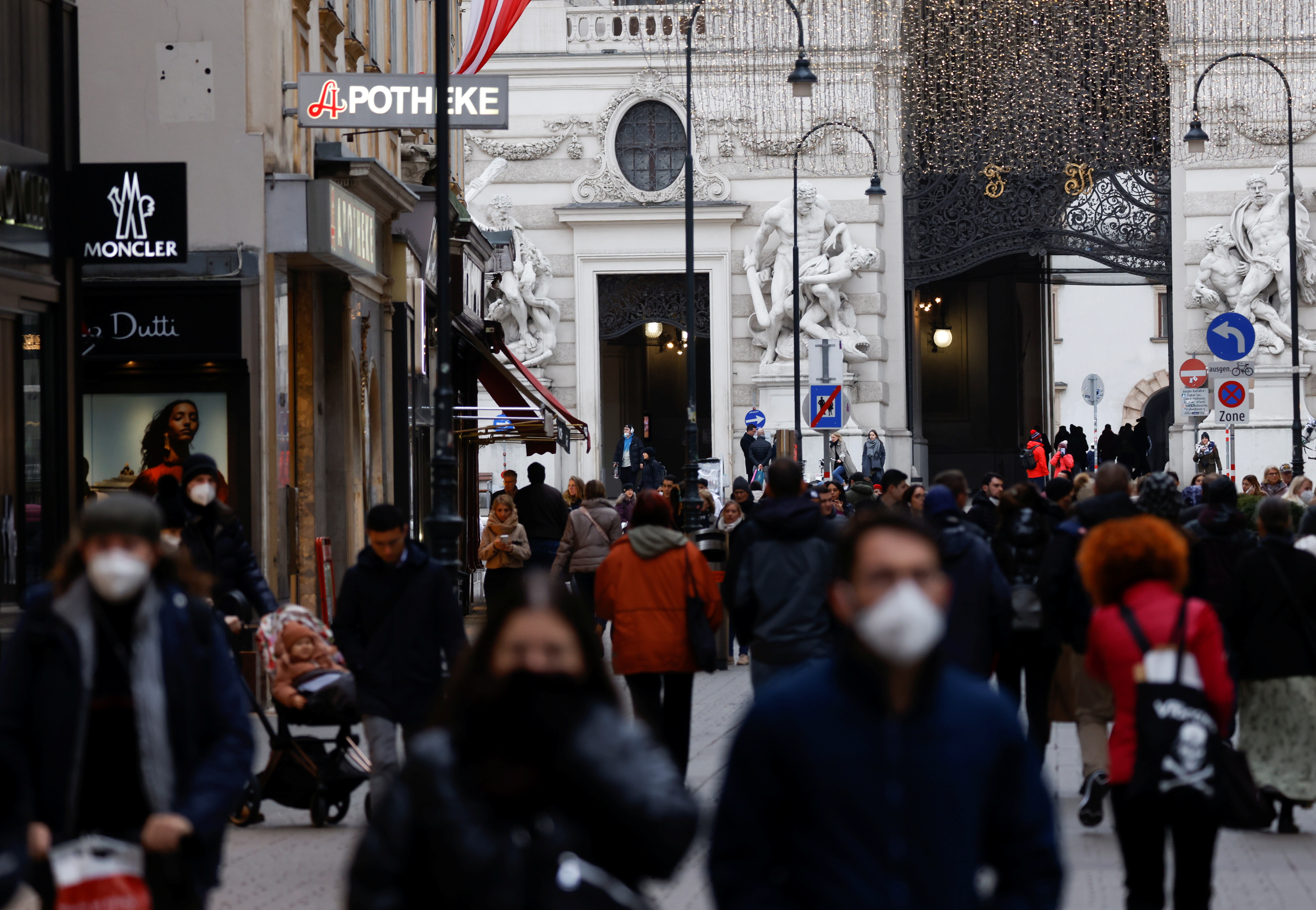 Pedestrians walk along a shopping street after the Austrian government placed roughly two million people who are not fully vaccinated against the coronavirus disease (COVID-19) on lockdown, in Vienna, Austria, November 17, 2021.   REUTERS/Leonhard Foeger