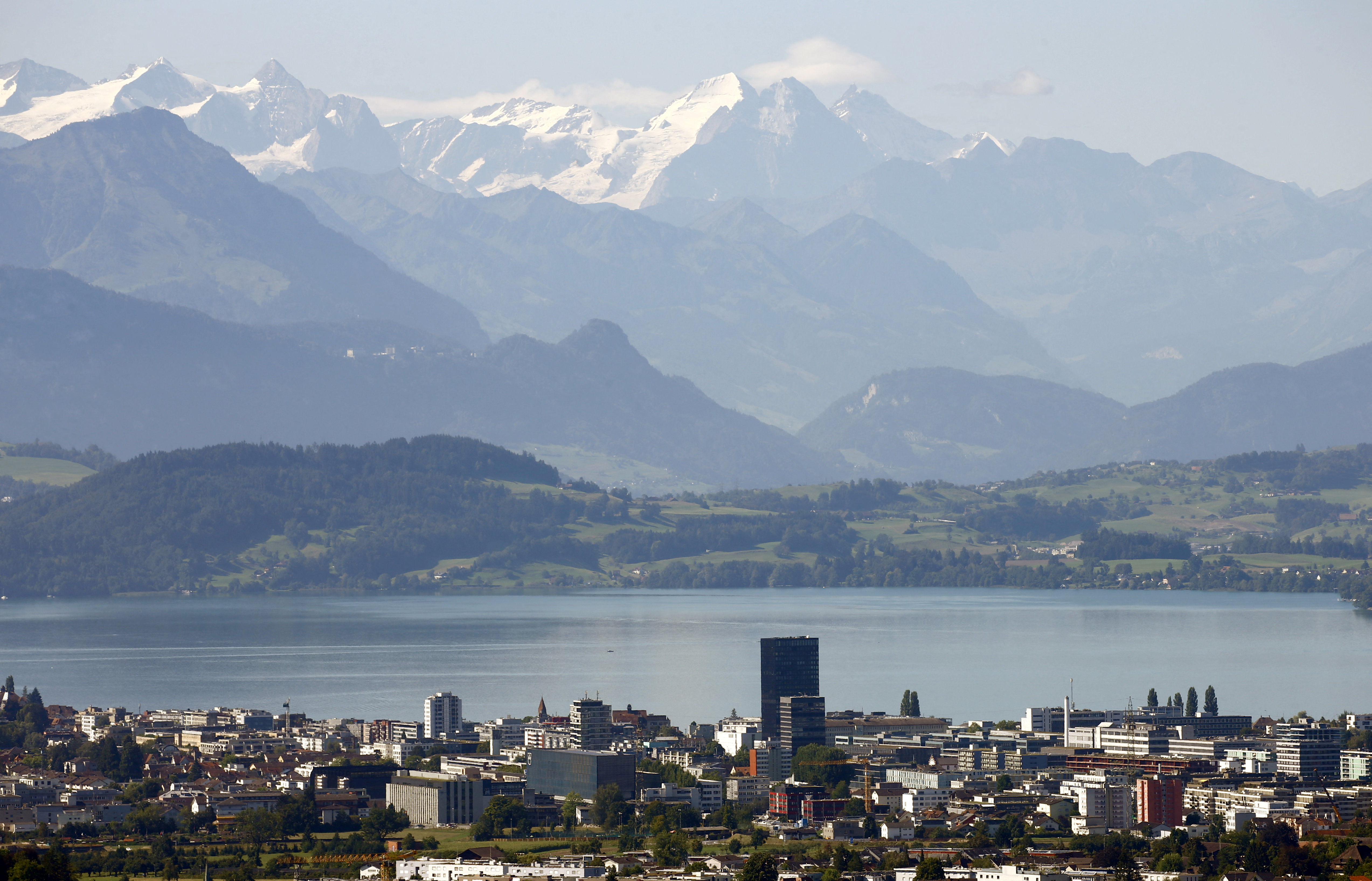 Peaks of Bernese Oberland are seen behind Lake Zug and the city of Zug