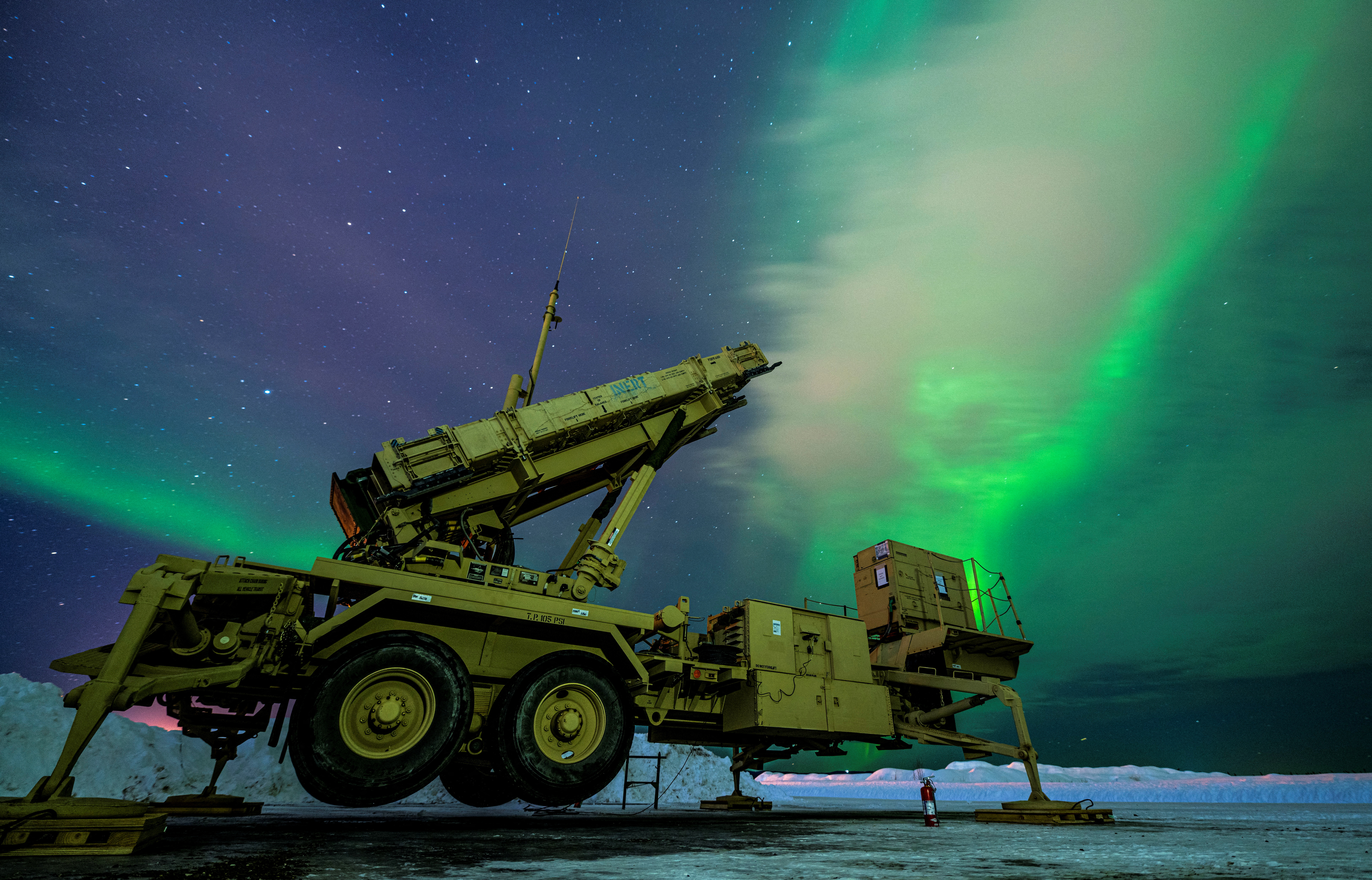 The northern lights glow behind a Patriot missile M903 launcher station in Alaska