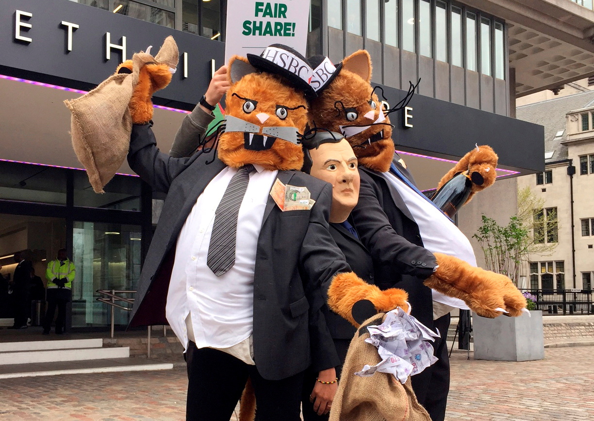 Protestors wearing costumes pose outside the venue for the HSBC AGM in London