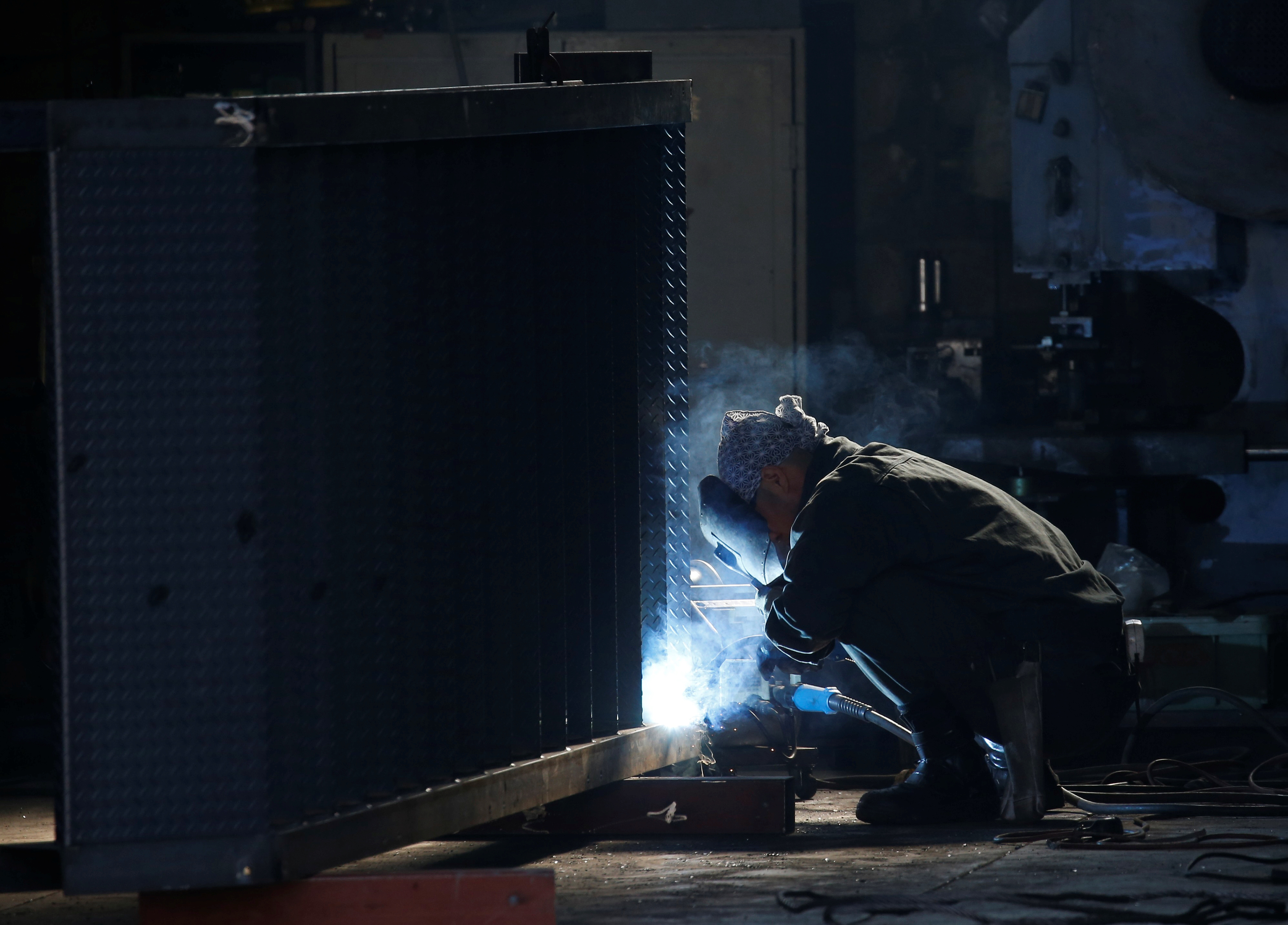 A man works at a factory at the Keihin industrial zone in Kawasaki