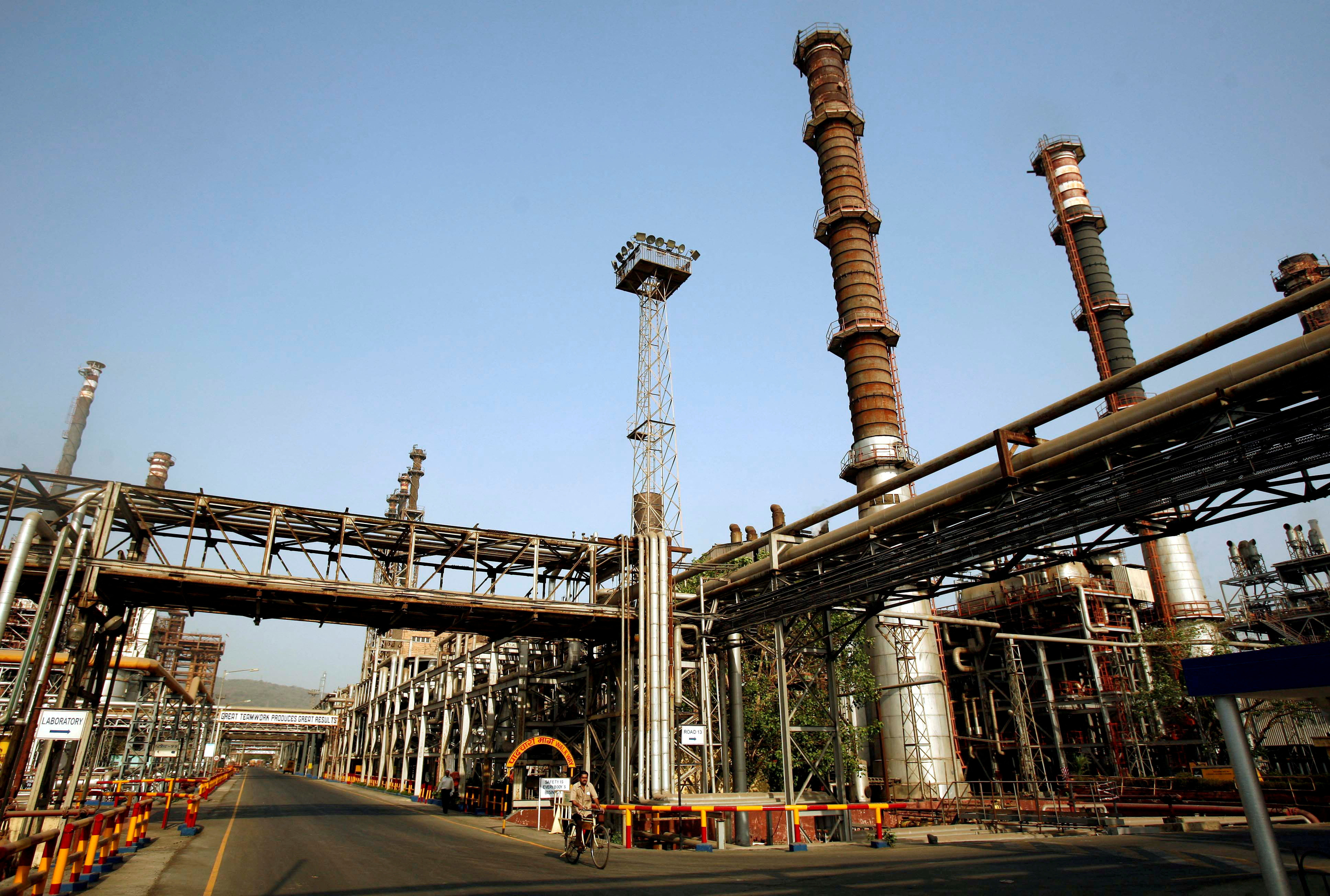 FILE PHOTO: A worker rides a bicycle at the Bharat Petroleum Corporation refinery in Mumbai