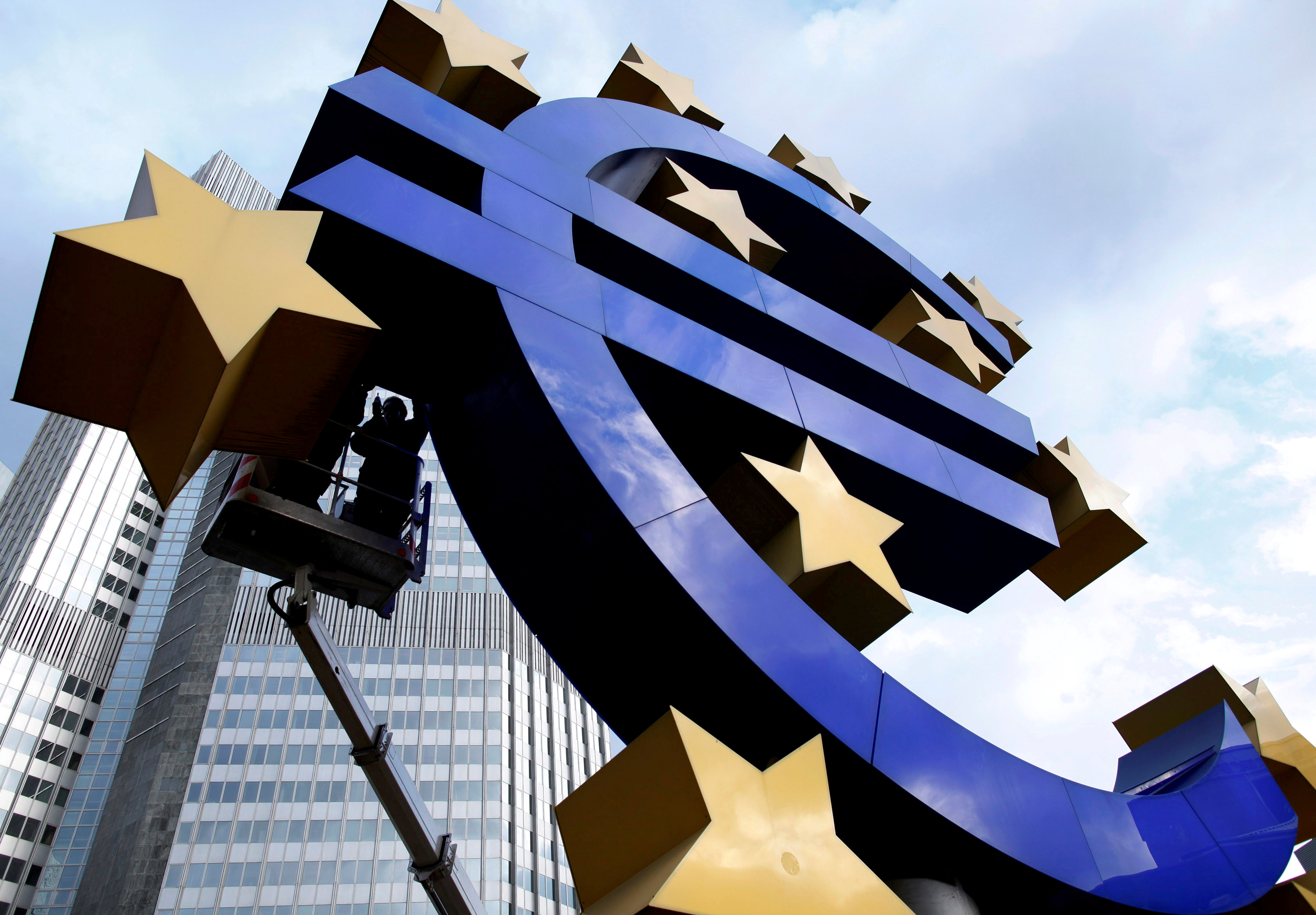 Workers maintain the huge Euro logo in front headquarters of ECB in Frankfurt