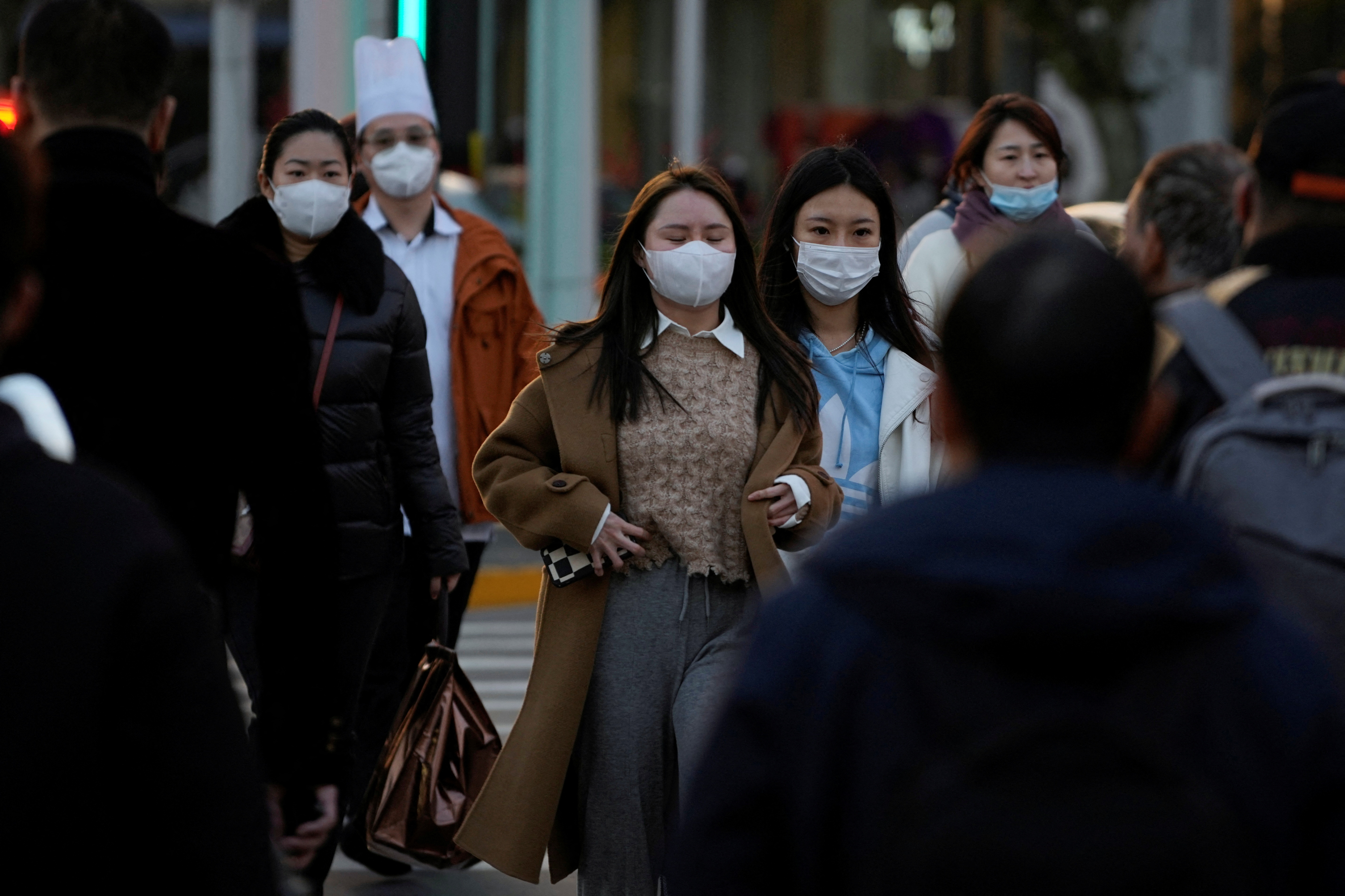 People wearing masks cross a street, as coronavirus disease (COVID-19) outbreaks continue in Shanghai