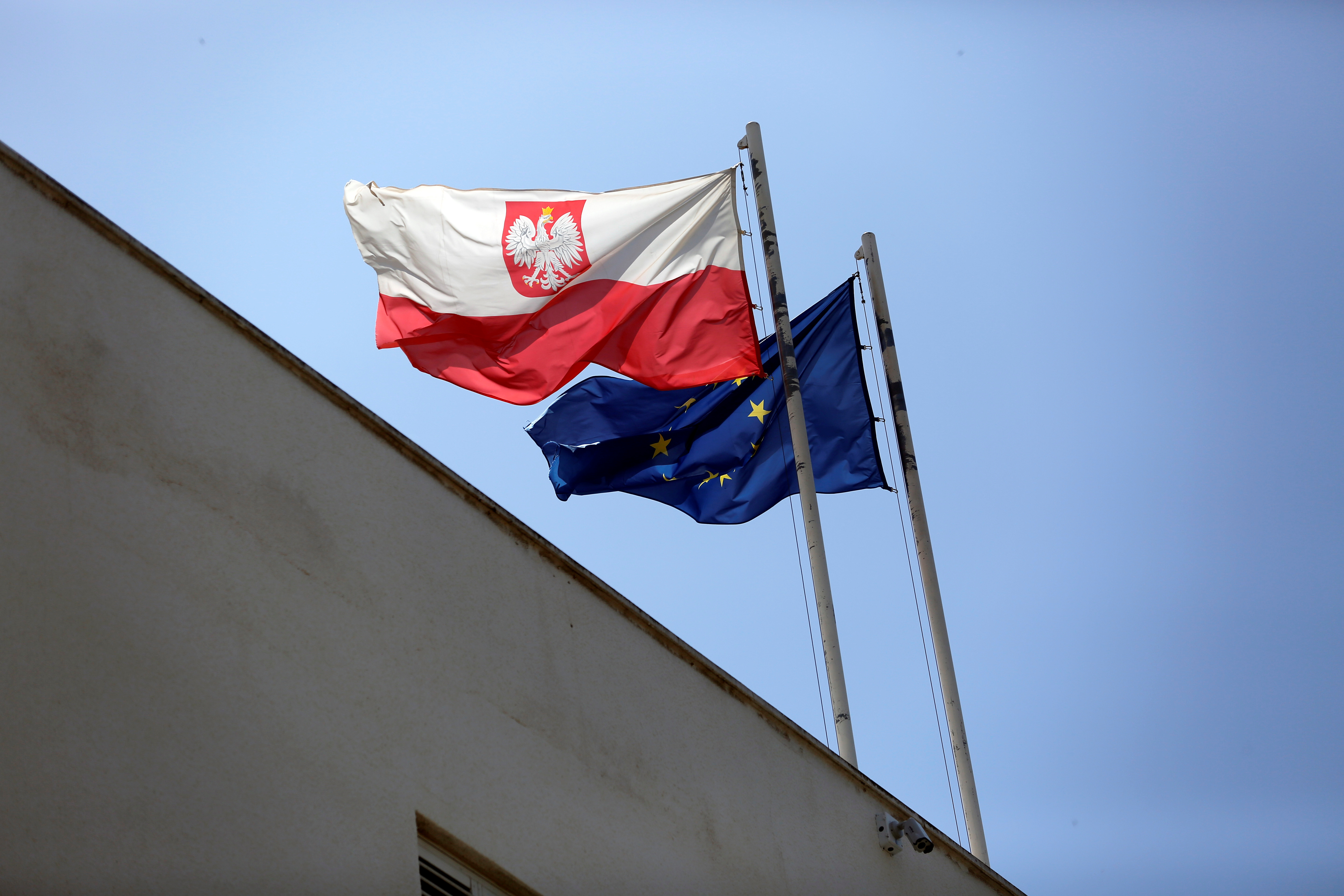 Poland's flag flutters near the European Union flag on the building of the Polish Embassy in Tel Aviv, Israel