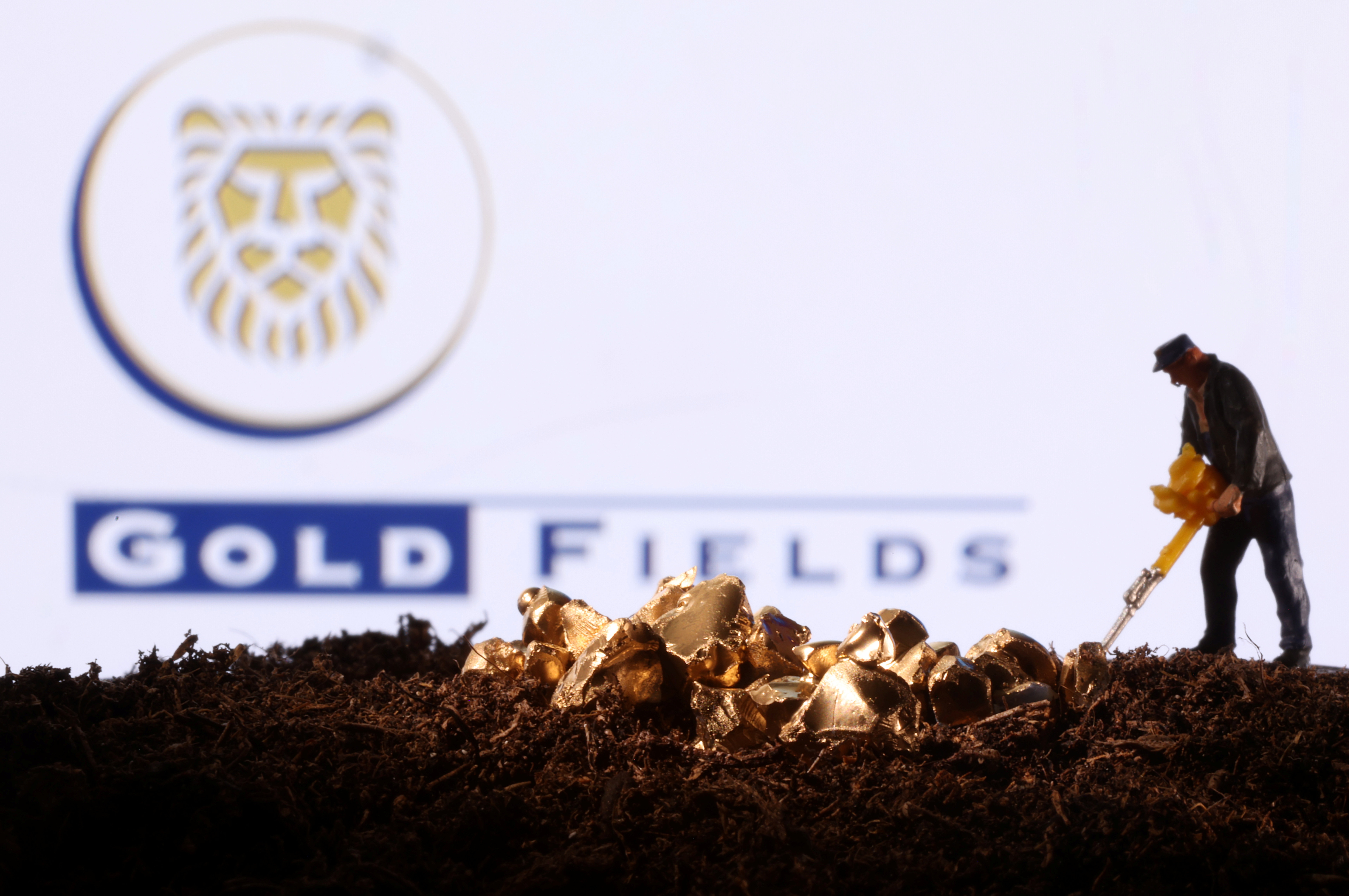 Small toy figure and gold imitation are seen in front of the Gold Fields logo in this illustration