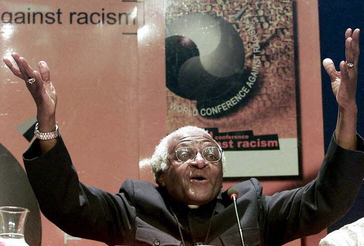 Nobel Peace laureate Archbishop Desmond Tutu gestures as he addresses journalists at the World Confe..