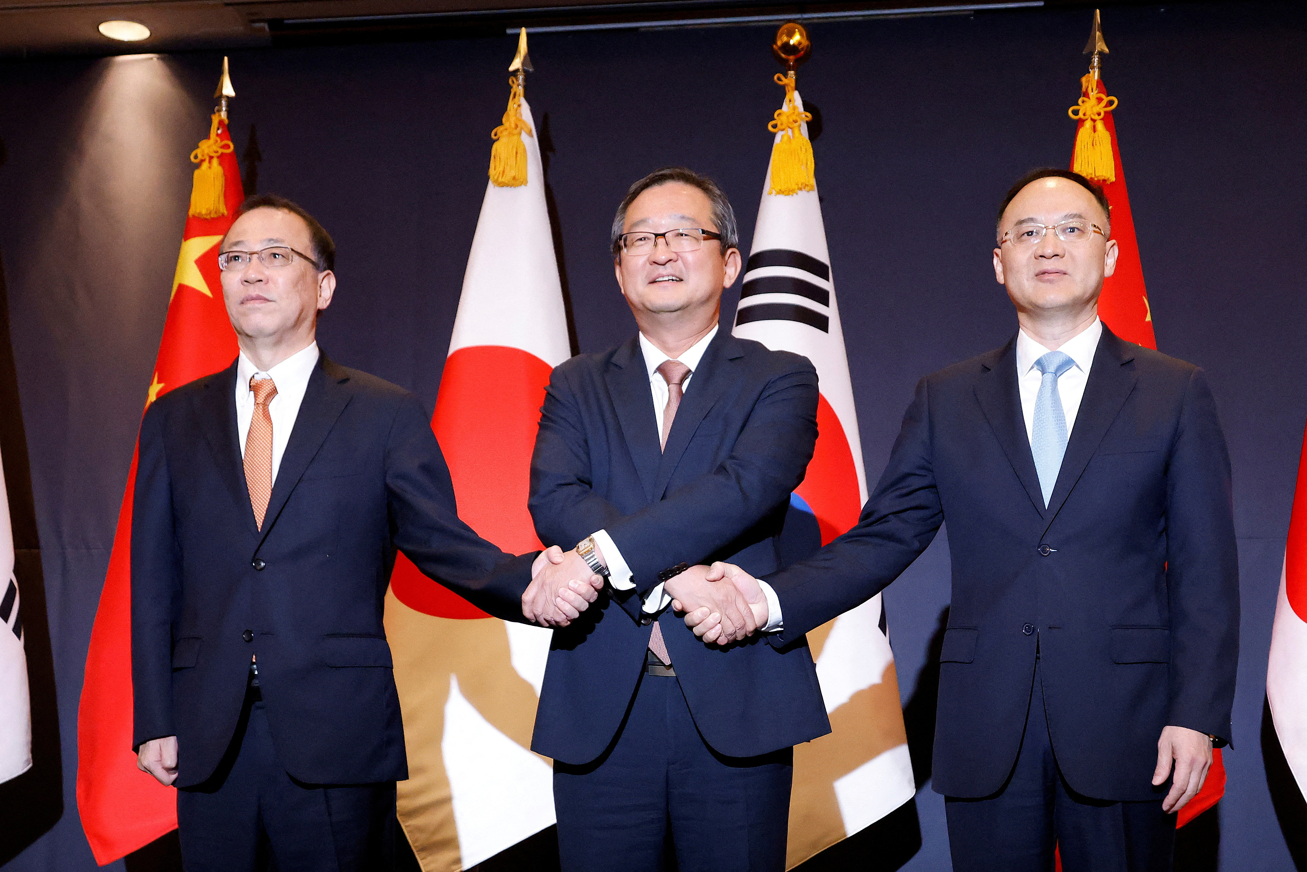 South Korea's deputy foreign minister for political affairs, Chung Byung-won, Japan's Senior Deputy Minister for Foreign Affairs, Funakoshi Takehiro, and China's Assistant Foreign Minister, Nong Rong, pose for photographs during their meeting in Seoul