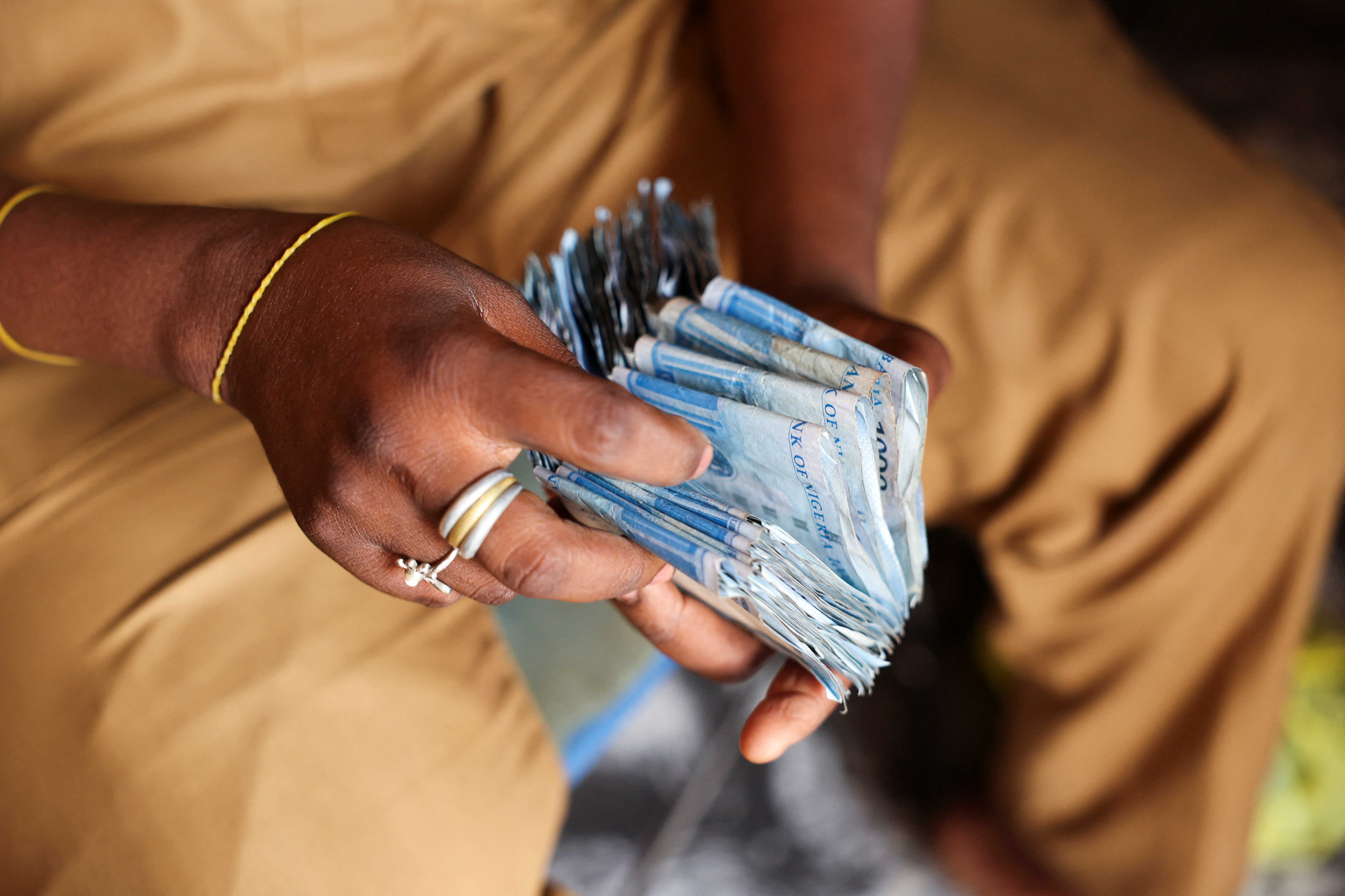 Man counts Nigerian naira notes in a market place ahead of Nigeria's Presidential elections in Yola