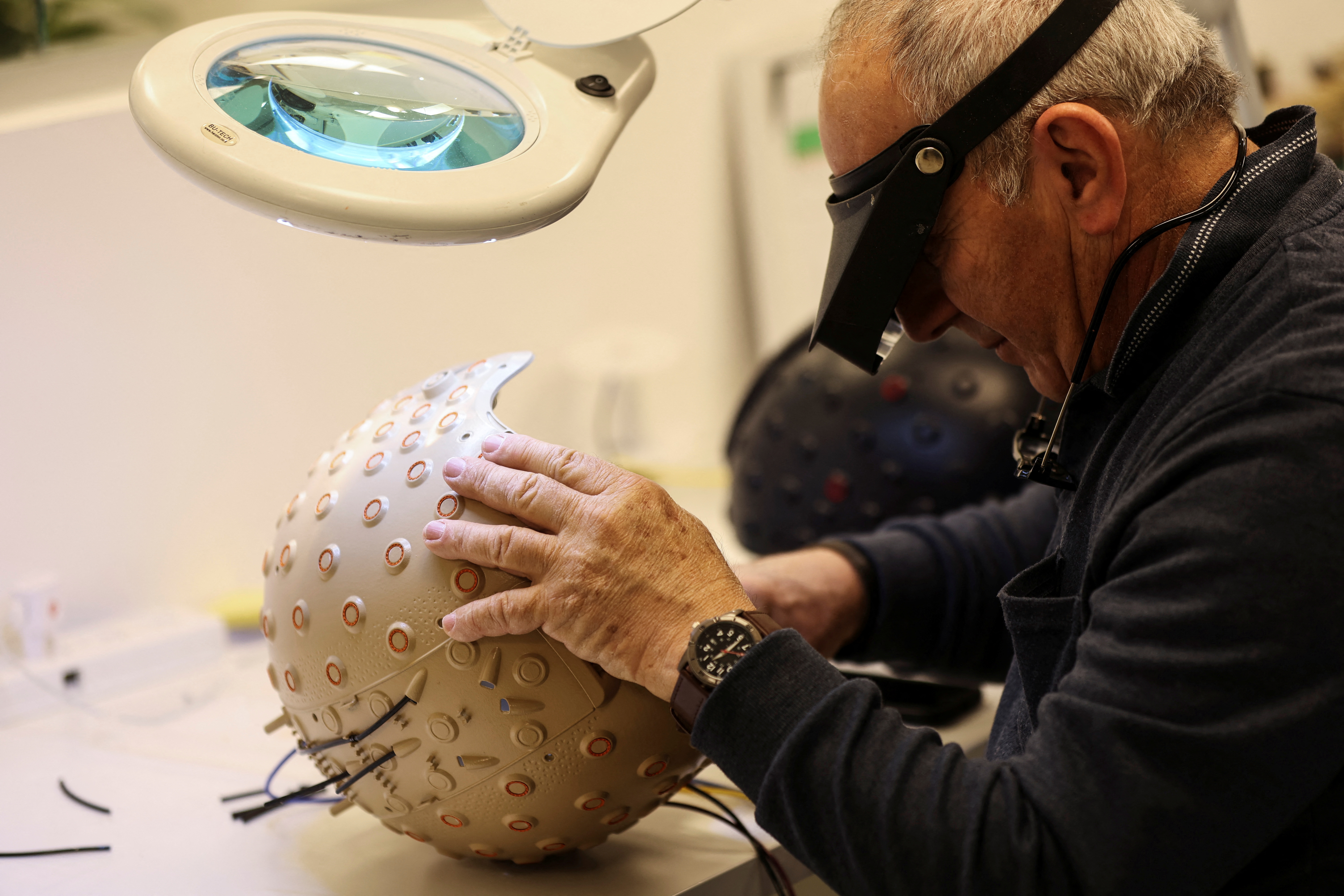 A worker at the Israeli startup Brain.Space builds an EEG enabled helmet, due to be used in an experiment on the impact of a microgravity environment on the brain activity, in Tel Aviv