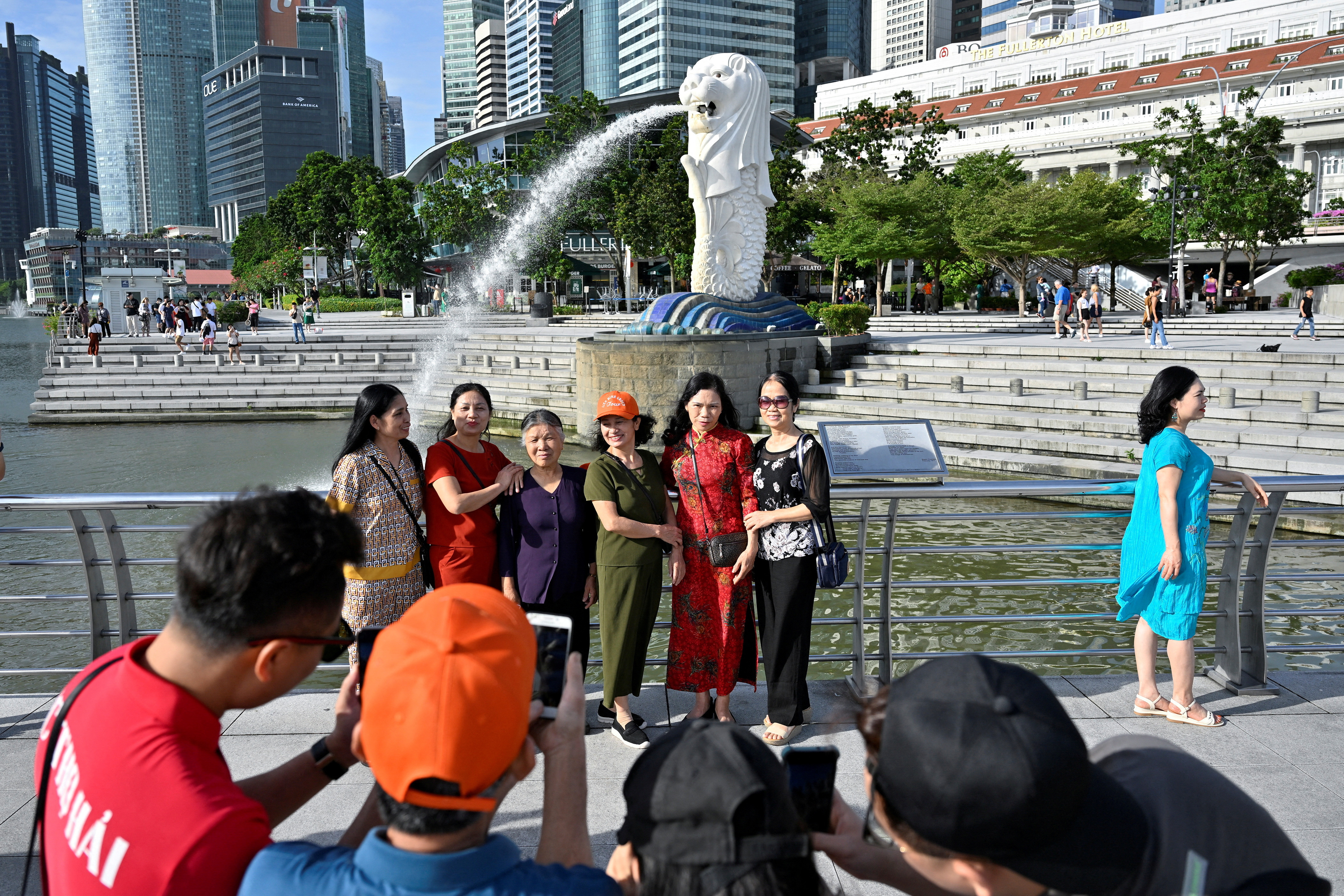 Tourists pose for photographs at Merlion Park in Singapore