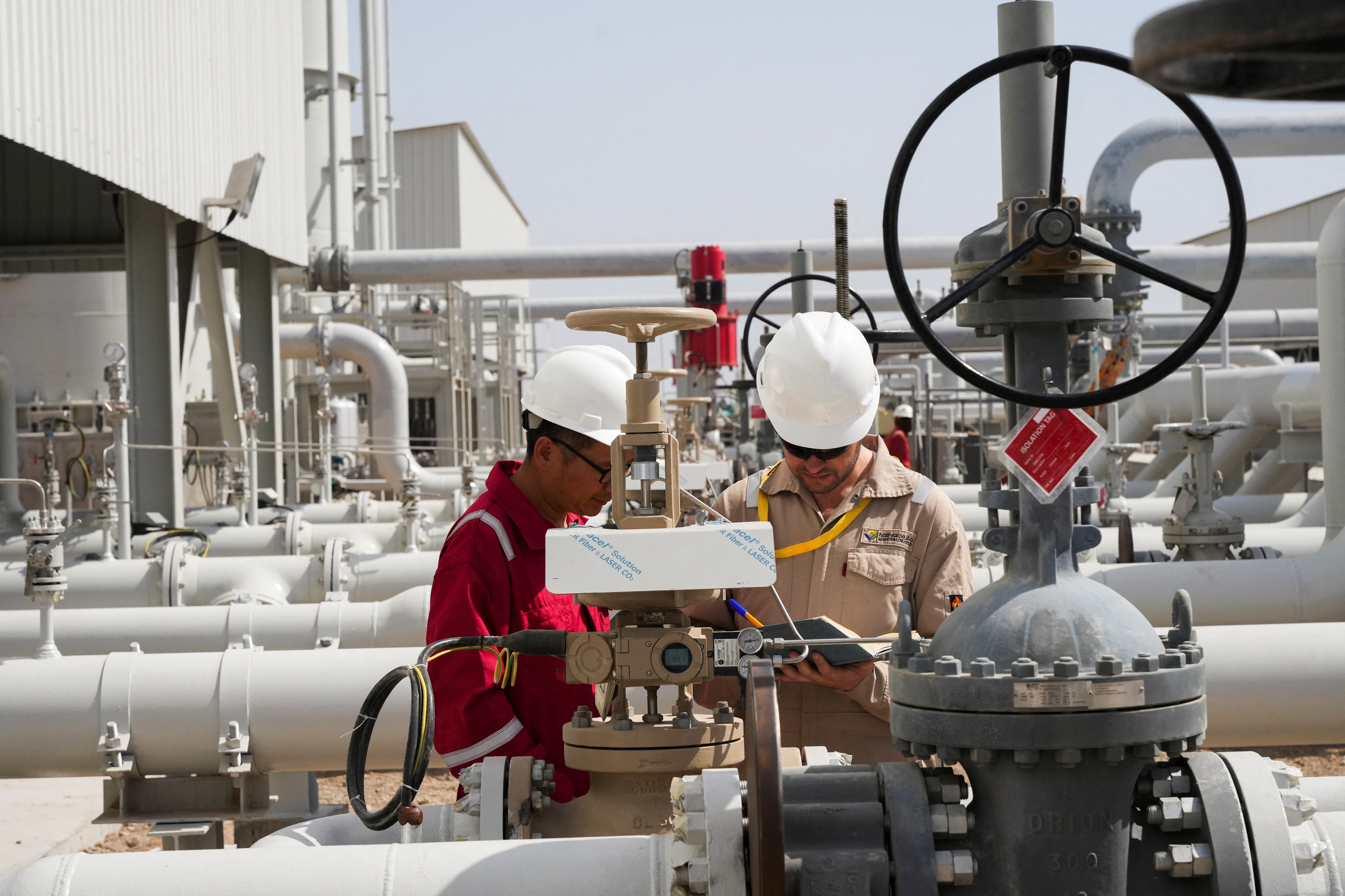 Workers work at Majnoon oil field near Basra