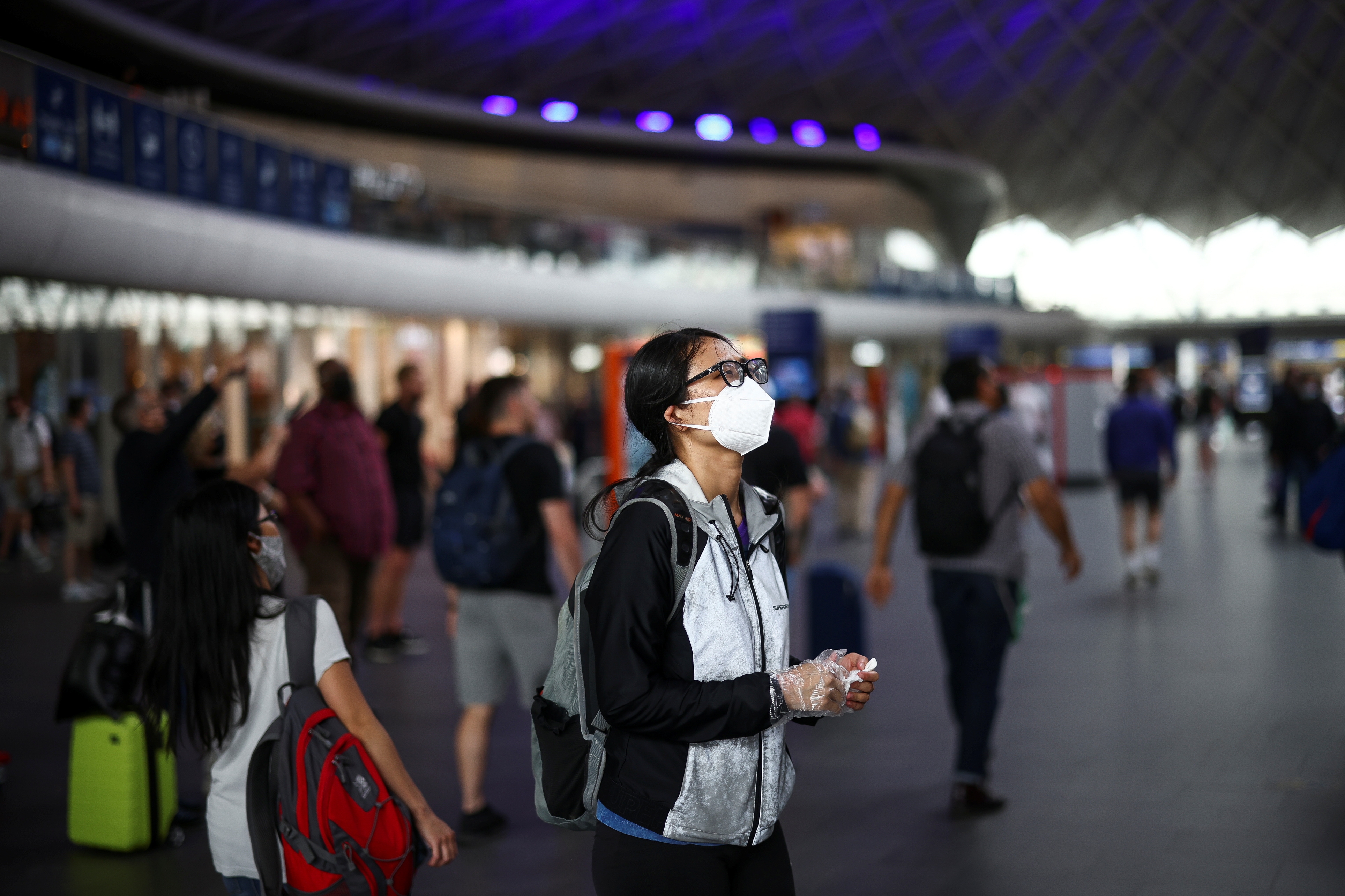 A person wearing a protective face mask stands in King's Cross Station, amid the coronavirus disease (COVID-19) outbreak in London