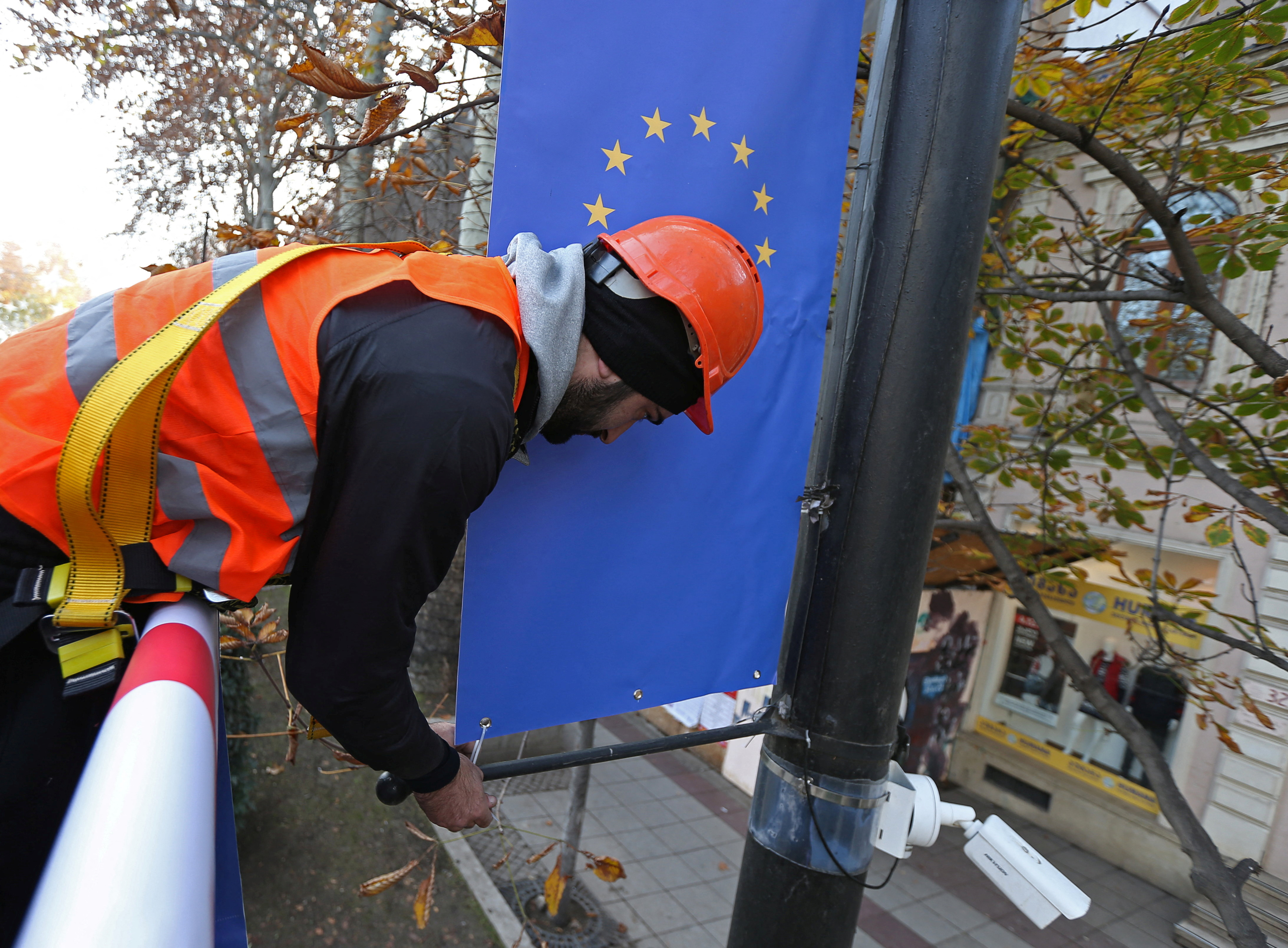 A worker hangs a banner with a European Union flag in Tbilisi