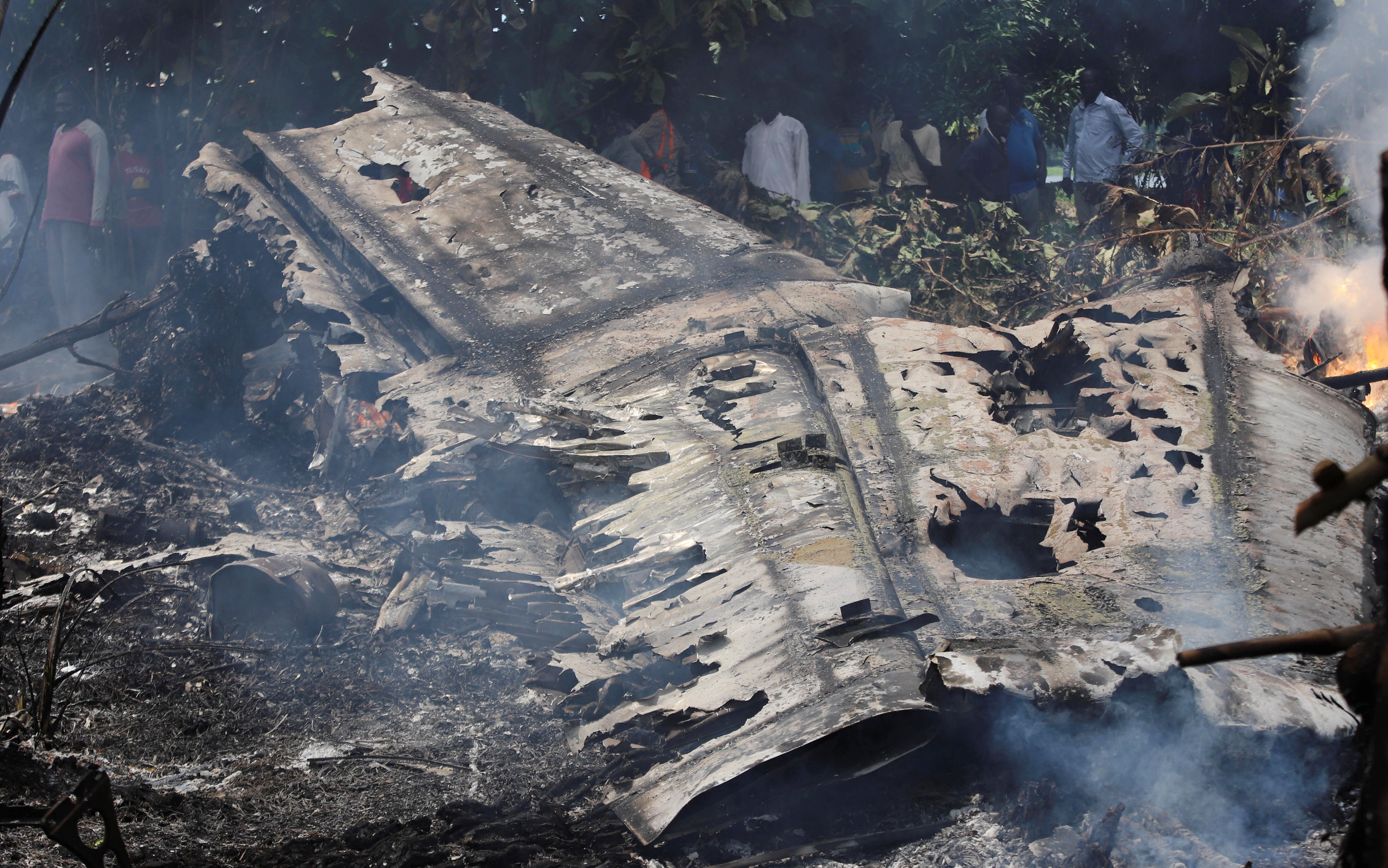 Civilians stand near the burning wreckage of an Antonov-26 plane operated by Optimum Aviation, that crashed shortly after take-off from Juba Airport in Juba