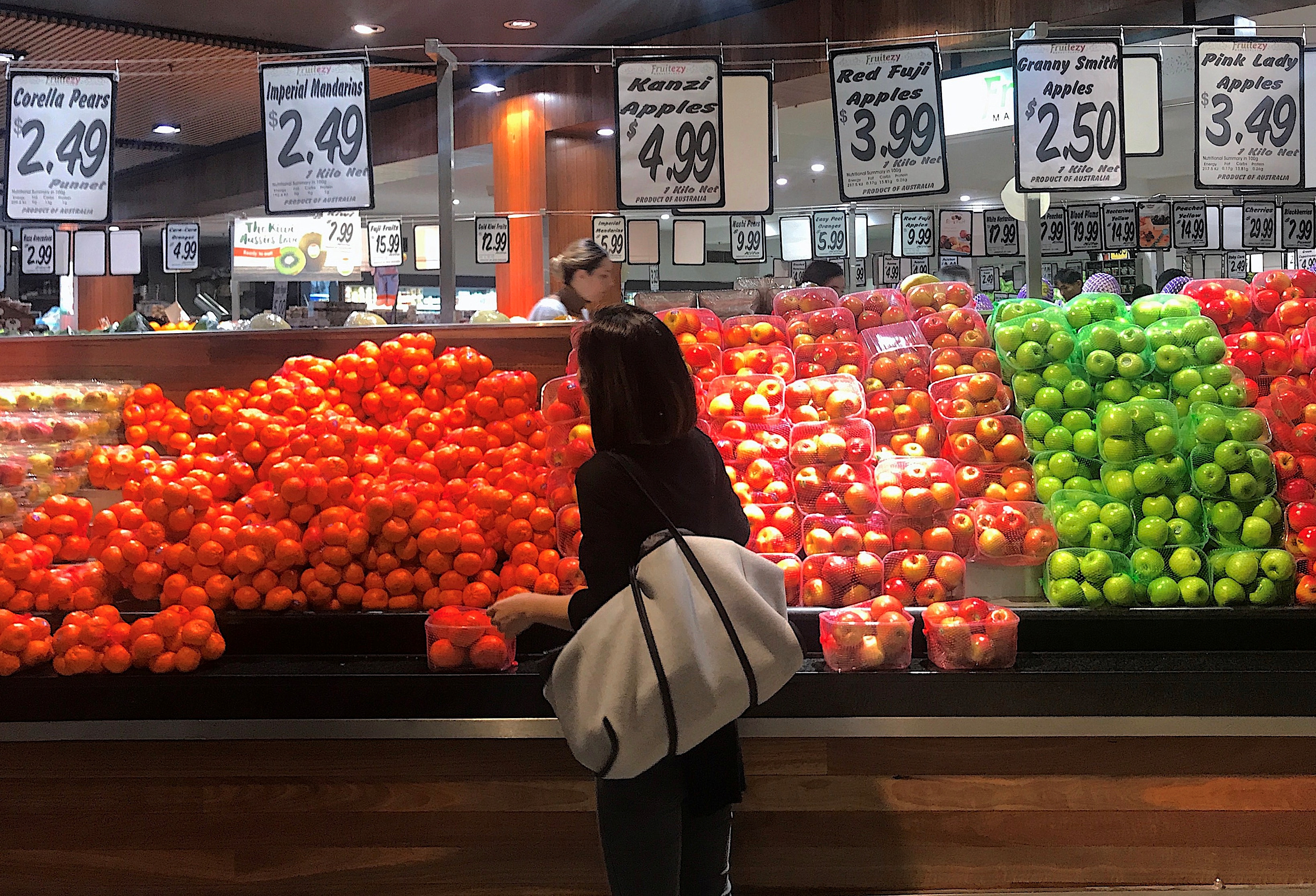 A shopper looks at a range of fruit and vegetables on sale at a store in a shopping mall in Sydney, Australia