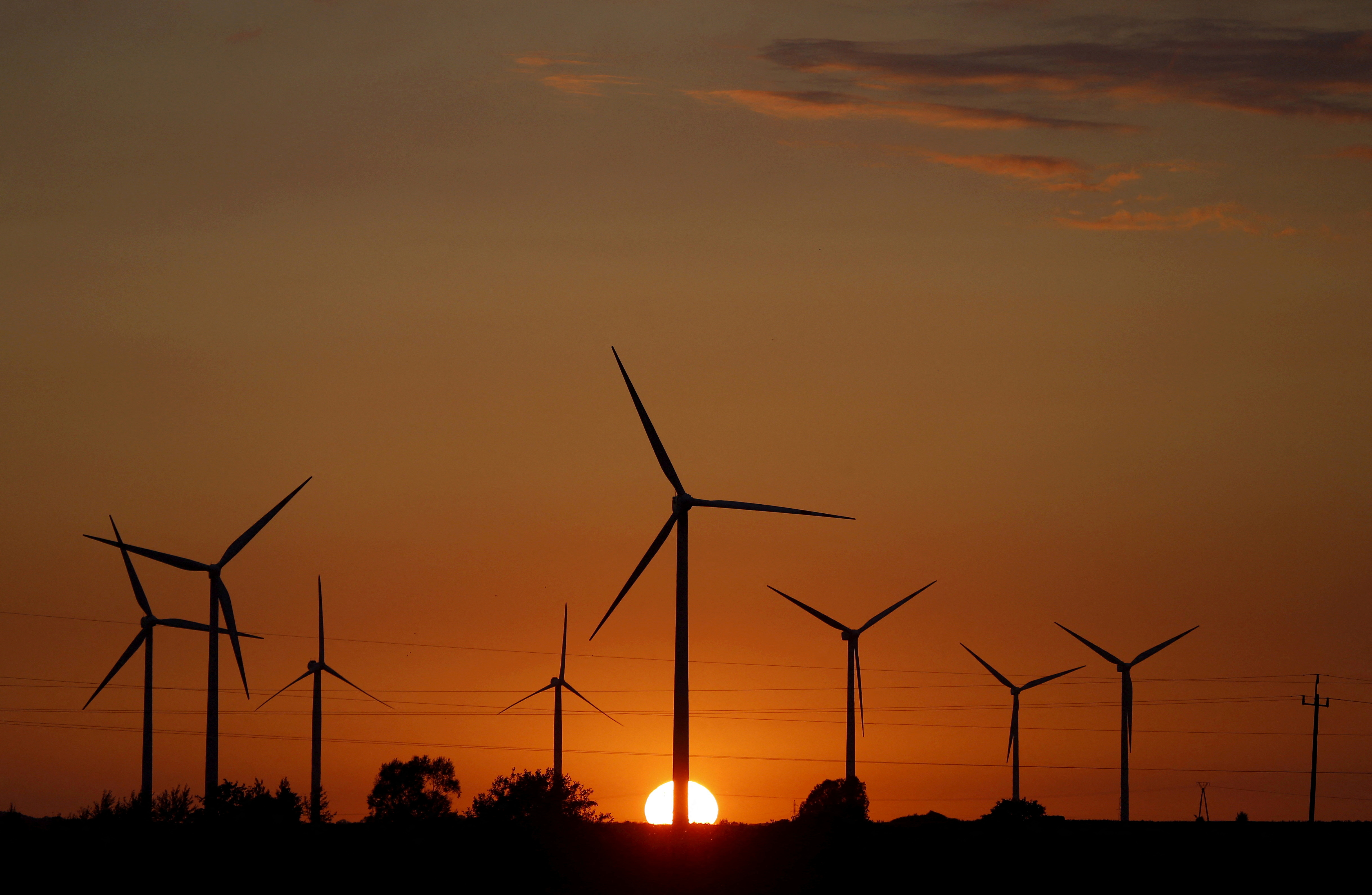 FILE PHOTO: A sunset is seen through a wind farm near Puck
